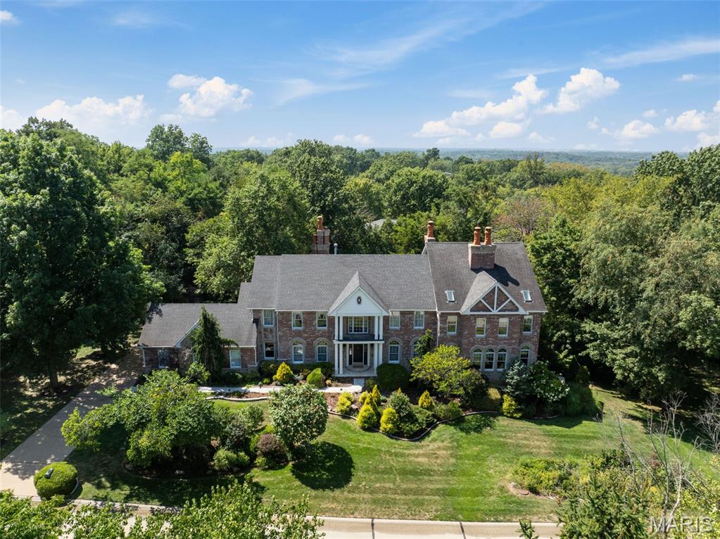 You couldn't build this stunning custom home on an acre in Lindbergh School District for under 3 million- This absolutely outstanding Rehnquist-designed full brick and stone masterpiece, enhanced by a remarkable two-story addition, nestled on a private park-like cul-de-sac setting. This 5-bedroom, 4.5-bath retreat is truly exceptional, showcasing stunning curb appeal, lush gardens, and a sparkling pool. Inside, custom craftsmanship shines with 6 wood-burning fireplaces, hardwood floors, soaring ceilings, and breathtaking views from every window.
A grand 2-story entry opens to a private dining room and executive office. The chef’s kitchen with custom cabinetry and breakfast room flows seamlessly into a vaulted hearth room with access to the flagstone patio, playground, gardens, and 3-car rear-entry garage. The living room offers a wet bar and oversized bay window with pool views. The spectacular addition will take your breath away—featuring arched, wood-beamed ceilings, heated traverntine floors, Palladian windows, three French doors, and a marble fireplace, connecting to a handsome library.
Upstairs, the primary suite boasts two bonus rooms—ideal for a yoga studio or art space—plus a spa-inspired bath with dual vanities, custom tile, Jacuzzi tub, and glass shower. A Jack & Jill bath serves two bedrooms, while two additional bedrooms share a full bath.
The walkout lower level is designed for entertaining with a billiards room, bar, gym, and sauna. Multiple system upgrades, including a new 75-gallon water heater, complete this one-of-a-kind home.