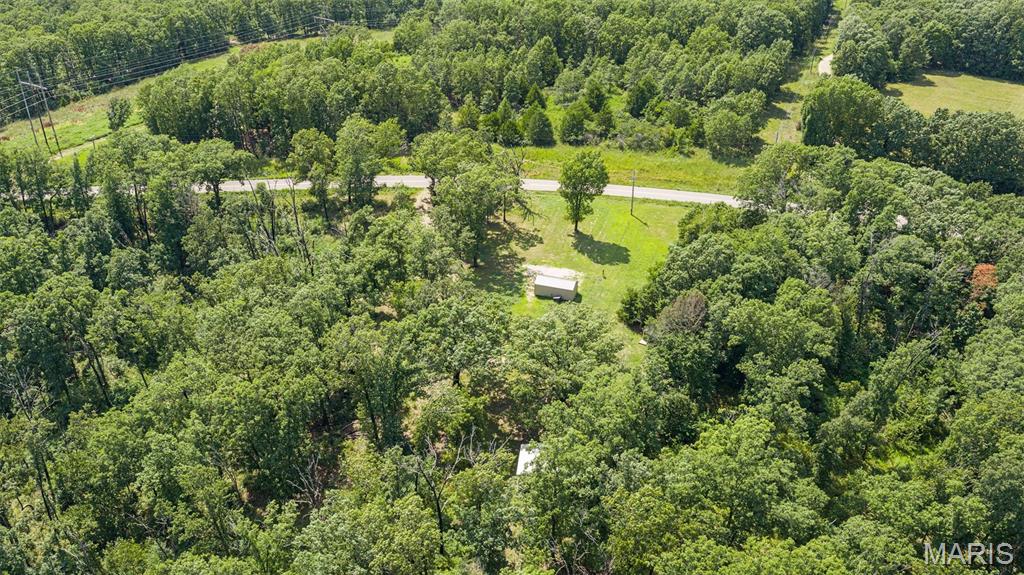 58+/- wooded acres in Morgan County, Missouri, offering an excellent opportunity for hunting, recreation, or a private getaway in a scenic location just north of the Osage River. The property features gently rolling, primarily wooded terrain with paved frontage along a state highway T, providing convenient year-round access. The property is equipped with electric service and a well, along with a shed and an additional outbuilding, providing useful infrastructure for recreational use, storage, or future improvements. The combination of timber, rolling terrain, and a location between Truman Lake and Lake of the Ozarks creates excellent potential for hunting, wildlife viewing, hiking, camping, and other outdoor activities. Located just north of the Osage River and within easy reach of both Truman Lake and Lake of the Ozarks, this property offers convenient access to some of central Missouri's premier outdoor recreation. Whether you're looking for a hunting tract, weekend retreat, recreational property, or a place to establish a private rural getaway, this 58+/- acre tract is worth a look. The property is located within the Morgan County R-1 School District and offers a combination of location, accessibility, existing utilities, and recreational potential. Come explore the possibilities this wooded Morgan County property has to offer.