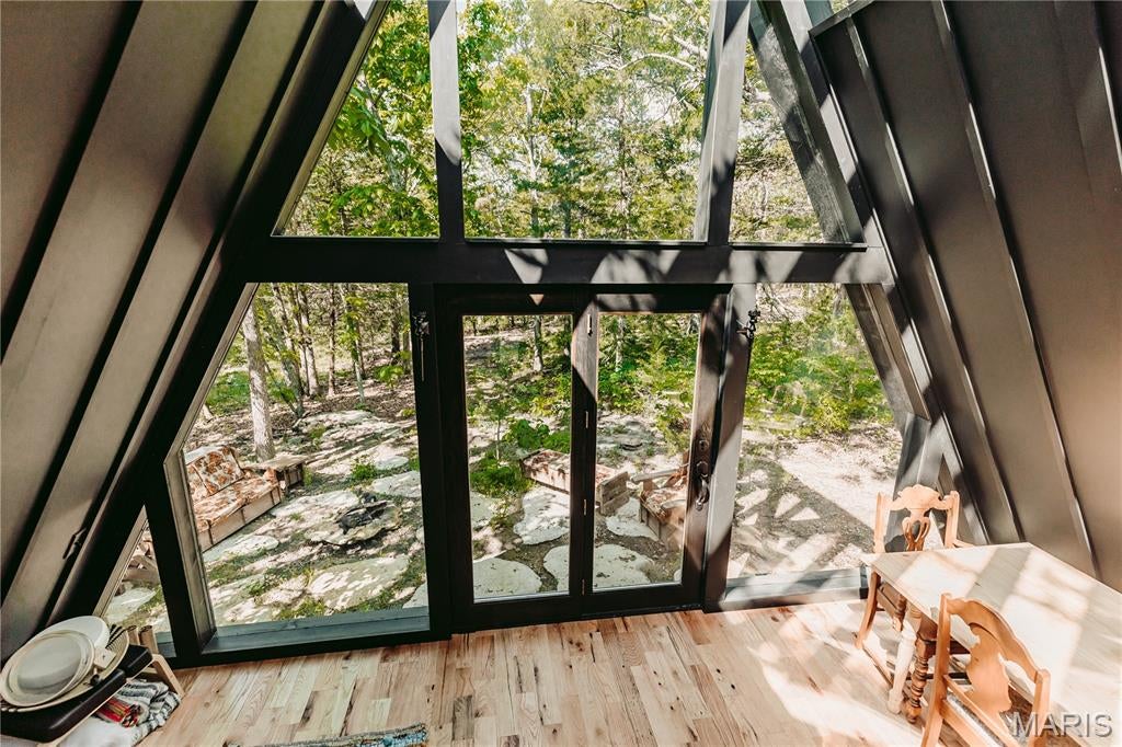 Endless possibilities await on this breathtaking 15-acre wooded retreat. Nestled among mature trees and accessed by a scenic circle drive, this one-of-a-kind property offers privacy, tranquility, and convenient access to the Lake of the Ozarks. The custom A-frame guest home is truly special, featuring a stunning windows in the loft sleeping area, allowing you to fall asleep under the stars. You'll find an inviting foyer, open-concept living space, kitchenette, custom-tiled bathroom, large windows that showcase the surrounding natural beauty, and an outdoor entertaining area perfect for relaxing or hosting guests. A picturesque rock water feature adds to the peaceful atmosphere. With its unique design and setting, the guest home offers exciting potential for personal enjoyment or future rental opportunities. The three-story A-frame main home is ready for new owners to bring their vision to life and complete this dream property. Whether you're seeking a private residence, family retreat, vacation getaway, or investment opportunity, the possibilities are endless. Experience the beauty, serenity, and potential of this remarkable property.
