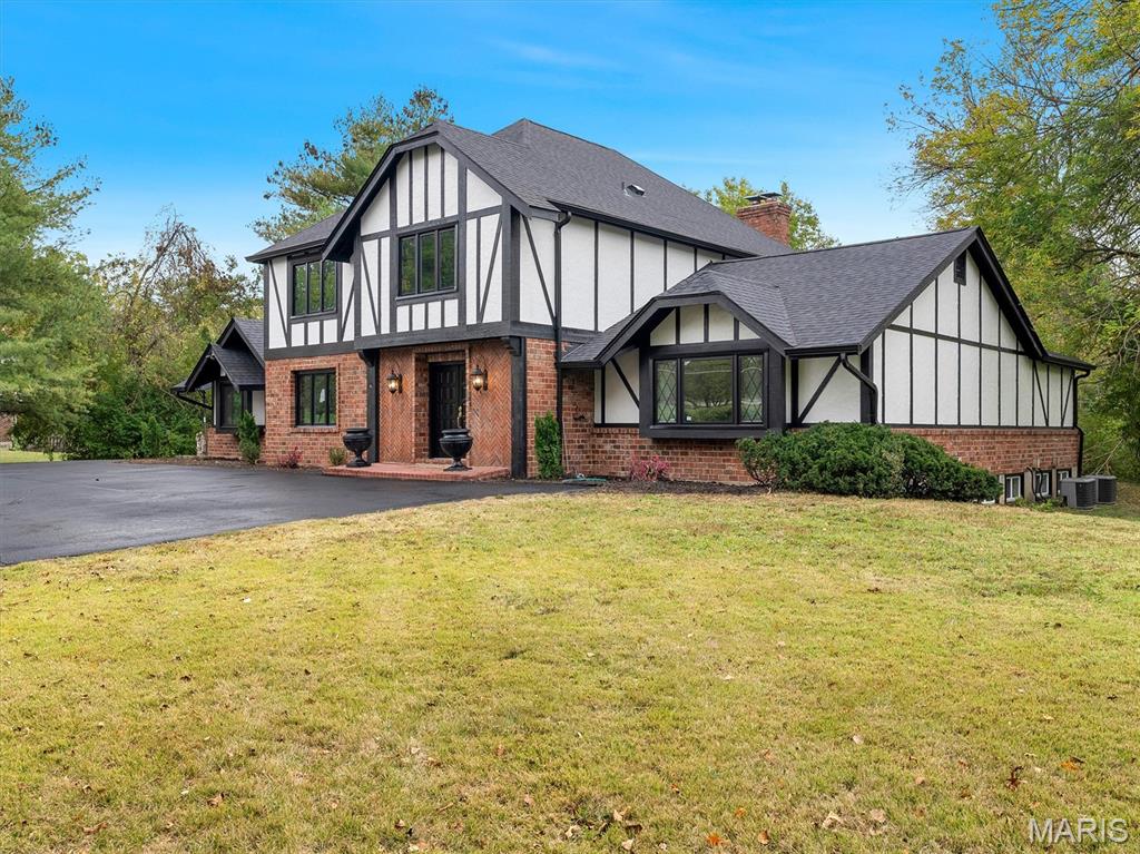 Welcome to 10656 Ladue Road — a masterfully renovated Tudor-style residence nestled on just over an ACRE in one of the most sought-after neighborhoods served by top-rated Ladue Schools. This home blends classic architectural charm with modern luxury and thoughtful design across more than 4,600+ sqft of living space. Step inside to find engineered white oak hardwood floors that flow seamlessly throughout the open and airy main level and second floor. The impressive vaulted great room is anchored by a floor-to-ceiling fireplace, highlighted by exposed wood beams and abundant natural light pouring in from new energy-efficient windows. Every detail of this renovation reflects quality craftsmanship and timeless style. The heart of the home is a brand-new chef’s kitchen, featuring quartz countertops, custom cabinetry, and professional-grade appliances, including a 36” gas range with convection oven and a Viking dishwasher. Elegant Kohler and Delta fixtures add a refined touch, while the open layout makes entertaining effortless. The main-floor primary suite is a private retreat with a spa-inspired bathroom offering heated floors, a luxurious walk-in shower, and designer finishes throughout. Convenience meets sophistication with a main-floor laundry room and a two-car attached garage. Upstairs, you’ll find three additional spacious bedrooms and two beautifully updated bathrooms, perfect for family or guests. This home features new electrical, new roof, and new windows, ensuring comfort and peace of mind for years to come. Outside, the property’s slightly over one-acre lot provides space for outdoor living, gardening, or future expansion. Whether you’re relaxing on the patio or hosting gatherings, the private, tree-lined setting offers the perfect backdrop for refined suburban living. This remarkable home offers the ideal combination of luxury, location, and lifestyle — all within minutes of premier dining, shopping, and amenities that make this one of the most desirable areas in the region.