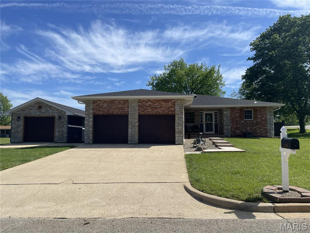 Beautifully remodeled home in a desirable neighborhood!  This move-in ready property has been extensively updated, including a new roof, gutters, windows, siding, kitchen, bathrooms, flooring and fresh paint throughout.  Step inside through the welcoming entry from either the front door or the attached garage.  The inviting living room features a charming decorative fireplace and patio doors that open to a concrete patio and a private, fenced backyard-perfect for relaxing or giving the kids and pets plenty of space to play.  The updated kitchen offers guartz countertops, quality appliances and a convenient breakfast bar for casually dining.  The home includes three generously sized bedrooms with walk-in closets and two beautifully remodeled bathrooms.  The primary bathroom features a modern walk-in shower.  Additional highlights include recessed lighting throughout and a partial basement with wide steps and a handrail, offering potential to finish for additional living space.  The basement also provides easy access to the crawl space through a large access door.  Car enthusiasts and hobbyists will appreciate the oversized two-car attached garage, complete with a hookup for a whole-house generator.  The property also features an impressive 16X30 detached garage/storage building with a concrete floor, electricity and insulation-ideal for a workshop, storage or extra vehicles.  Situated on a corner lot with a privacy-fenced backyard and exterior electrical outlets, this home truly has it all.  Nothing left to do but move in and enjoy!