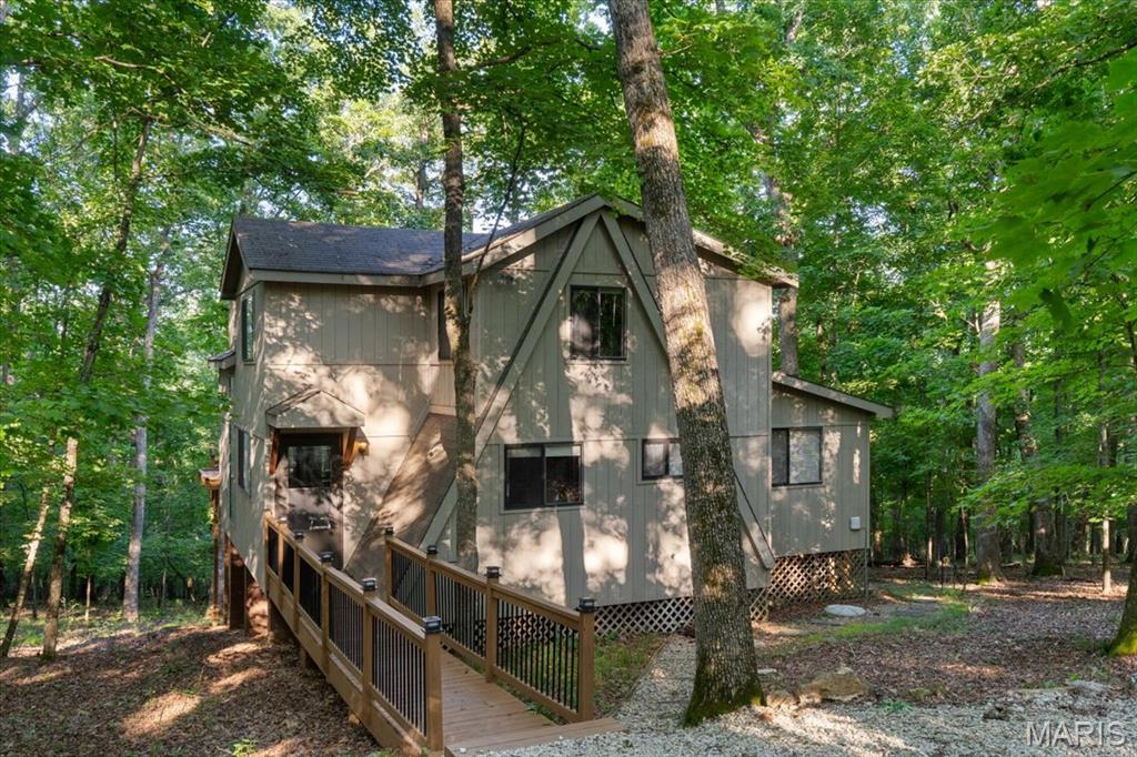 Whether you’re expanding your short term rental portfolio, searching for a peaceful vacation home, or dreaming of full time resort-style living, this turnkey chalet checks every box. Tucked inside the gates of Innsbrook Resort just an hour from St. Louis 2506 Alpine Woods Dr offers rustic charm, modern comforts, and unbeatable access to nature, recreation, and relaxation. Inside, you’ll find 18 ft vaulted ceilings, rich wood floors, and a dramatic floor to ceiling bay window that fills the living space with natural light. A cozy woodburning fireplace anchors the room, while direct access to the 4 seasons room and private deck makes this an ideal gathering spot year round. The kitchen exudes warmth with its natural wood tones and thoughtful layout. The expansive eat in peninsula offers the perfect spot for everything from breakfast with the family to evening wine with friends. The main floor primary suite features hardwood floors, vaulted ceilings, dual closets, and private access to the 4 seasons room. The en suite bath includes a walkin shower and comfort height vanity. 2 additional bedrooms, loft and full bath offer flexible sleeping arrangements for guests or family. Step outside to soak in the hot tub, take in the wooded views, or explore Innsbrook’s lakes, golf course, trails, pools and more. Located just steps from the resort’s largest 236 acre Alpine Lake this chalet offers easy access to swimming, fishing, and paddling. With a strong rental history and resort style amenities, it’s a rare opportunity for any buyer.
