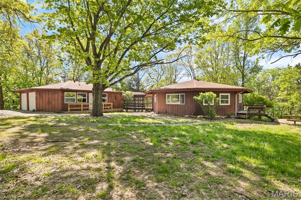 Location, woods, scenery, and acreage if that is what you are looking for, this is it!  Approximately 8.29 acres of private, scenic country living with a truly distinctive cedar sided octagon home. This 3 bedroom, 2 full bath residence offers a rare blend of architectural character and natural beauty, featuring soaring ceilings, stunning tongue and groove wood floors, and an open concept layout designed to capture breathtaking wooded views from every angle.
A covered wood deck seamlessly connects the home to the heated detached garage, offering approximately 650 additional square feet of versatile living space. Complete with a recreation room, full bathroom, laundry area, and wood stove (seller is unsure of functionality), this space is ideal for entertaining, guests, or a private retreat. The home also includes a 450 square foot basement with exterior access, perfect for storage.
Designed for efficiency and comfort, the property features geothermal heating and cooling (2012), along with thoughtful updates including a newer roof, living room and kitchen windows (2019), and a water heater in the garage (2024). The home is serviced by MJM Electric, EJ Water, and a private septic system.
The outdoor setting is equally impressive, offering a 28 x 46 outbuilding and a lean to building, providing ample room for equipment, hobbies, or recreational storage, all surrounded by peaceful wooded acreage.
For those seeking expanded land and investment potential, an adjoining 26.01 acre parcel (Parcel #16-26-300-014) is also available (see aerial in photos). This parcel includes 9.7 acres enrolled in CRP generating $3,543.62 annually, with contracts in place through September 2028 and September 2033. Combined acreage would total approximately 34.3 acres, offered at $490,000.