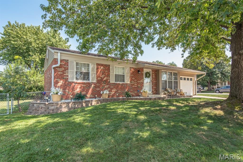 Welcome home to this charming three-bedroom, all-brick bungalow situated on a desirable corner lot with a fenced yard, patio space, and an oversized one-car garage. Inside, you’ll find beautiful hardwood floors, light and bright living room with bay windows,  an inviting kitchen featuring stainless steel appliances, an island, and a cozy eat-in area. The main level offers a full bathroom along with comfortable living spaces perfect for everyday living and entertaining.
The finished lower level adds even more versatility, featuring a huge family room with an electric fireplace and built-in bookshelves, a full bathroom, and two additional rooms that could be used as sleeping areas, a home office, den, hobby room, or whatever best fits your needs. The garage is currently set up as the ultimate man cave, but it still has plenty of room to accommodate a vehicle. With its classic brick exterior, flexible finished lower level, fenced corner lot, patio, and oversized garage, this adorable bungalow offers charm, functionality, and plenty of space to make it your own!