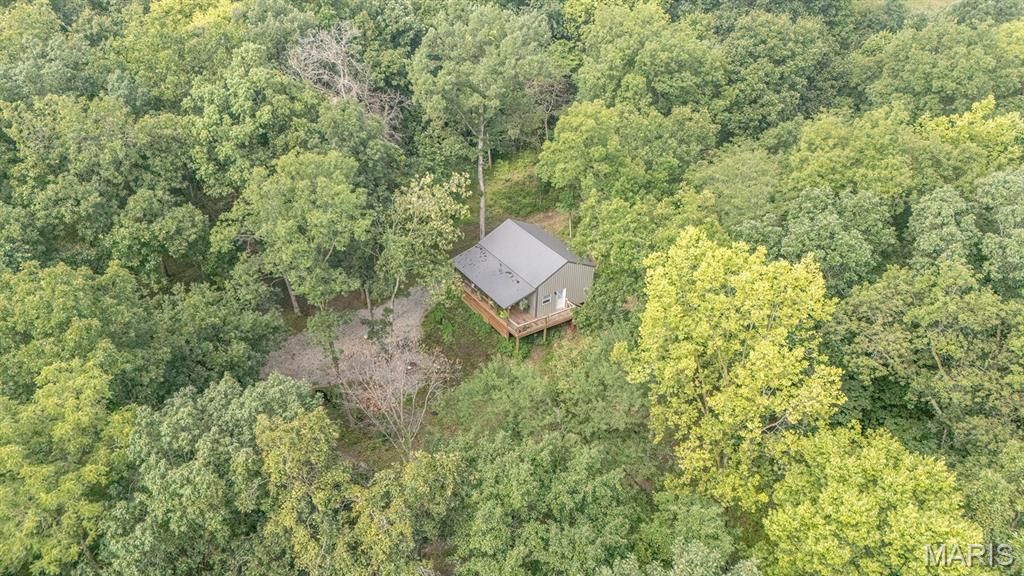 Here is a wonderful opportunity to own your very own country retreat and cabin in the woods. As you enter the
property, you’ll be greeted by a gated entrance. Once through the gate, follow the gravel driveway through
mature timber until you arrive at the cabin.  The cabin sits in an exceptionally private and peaceful setting, surrounded by beautiful, mature woods. It features two bedrooms, one bathroom, and an additional loft that provides extra sleeping space.

Step outside onto the covered front deck, the perfect place to relax, unwind, and take in nature's beauty. A spring-fed creek runs in front of the cabin, adding to the property's peaceful atmosphere and natural beauty.  Wildlife is abundant, with deer, turkey, and other small game calling the property home. An established trail system throughout the acreage provides opportunities for exploring, hunting, hiking, and enjoying the outdoors.  

If you’ve been looking for a private getaway, hunting retreat, or peaceful place to escape the hustle and bustle, this property offers a unique opportunity to enjoy the best of country living.  Additional acreage is also available for purchase for buyers interested in expanding their property.