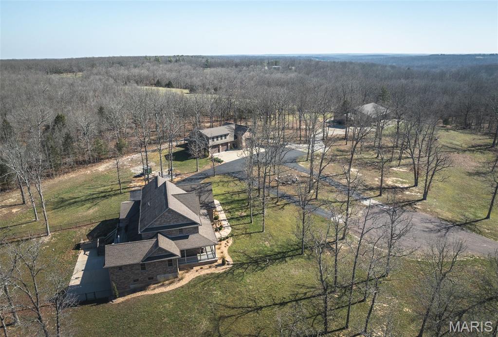 Custom-built home on approximately 14.16 acres located just a few miles from Salem. Built in 2015, this property offers approximately 4,275 square feet of living space in the main residence with 5 bedrooms, 3 bathrooms, and a partially finished walkout basement.

Interior features include granite countertops, hardwood flooring, ceramic tile, and carpet throughout various areas of the home. Heating and cooling systems include geothermal (closed-loop horizontal trench configuration), forced-air electric, and a wood furnace.

The property includes four attached garage spaces at the main residence, along with a fenced backyard area featuring a hot tub. A 40 x 80 metal barn with electric service provides additional storage, workspace, or utility options.

A separate detached living space offers approximately 1,712 square feet with 1 bedroom and 1 bathroom, plus an additional bathroom and laundry area located on the lower level. This structure also includes four attached garage spaces, including one approximately 20 x 40 with a wash bay.

The acreage offers a combination of residential space, open ground, and functional outbuildings, providing flexibility for a variety of uses.

Square footage, measurements, acreage, and all property details to be verified by buyer or buyer’s agent.