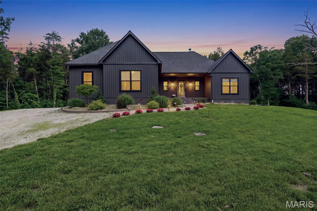 Country roads, take me home… preferably to 18 private acres with deer in the yard, a creek running through the woods + not a single neighbor in sight ;) Welcome to this custom built 5 bed, 4 bath Hillsboro retreat, where luxury finishes and wide-open skies somehow coexist perfectly. Built just four years ago + expanded since with additional beds and baths, this home feels like the kind of place people dream about leaving the hustle + bustle of the city for. The winding private road, stamped concrete walkway, moody exterior + soaring rooflines immediately set the tone. And while the curb appeal is incredible… there’s technically no curb here to appeal from ;) Inside, blonde hardwood stretches throughout the open floor plan while oversized windows pull the outdoors into every corner of the home. The dramatic floor-to-ceiling black stone fireplace anchors the family room beautifully + practically demands an oversized sectional, Christmas tree + someone yelling “whose turn is it to grab firewood” from the couch. The kitchen is equal parts functional + beautiful with black granite countertops, white cabinetry, brushed gold hardware, oversized island seating, stainless appliances + a walk-in pantry with enough storage to survive both Costco runs and your “maybe we should start canning vegetables” era. Nearby dining space opens directly onto the covered stamped concrete patio where a ceiling fan spins overhead, the natural stone waterfall pond bubbles nearby + frogs provide what might honestly be better background noise than Spotify (which btw, you can easily use if preferred - the property is equipped with internet access via Starlink satellite). The primary suite feels like a private resort tucked into the woods with a wood-paneled tray ceiling, private deck access, hot tub, oversized walk-in closet + a spa-worthy bath featuring a massive vanity, marble-look shower, rainfall shower head, detachable shower head + enough counter space for every skincare product social media convinced you to buy ;) Four additional bedrooms offer endless flexibility for guests, kiddos, offices, workout spaces or hobbies. Outside is where this property really starts showing off. Trails weave throughout the acreage for hiking, biking or four-wheeling. A creek with cascading limestone waterfalls comes alive in the springtime and wildlife is everywhere. The basketball court doubles as overflow parking for gatherings, the heated 3-car garage has room for every outdoor toy imaginable, and the privacy is unmatched. Add in the water softener + filtration system, gardens, storage galore, and neighbors close enough to look out for one another, but far enough away that you’ll never actually see them. Country roads really *did* take us home on this one. Cheers!