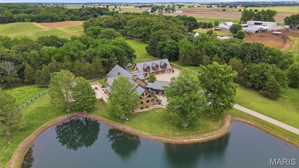 MORE DETAILS COMING SOON! Extraordinary luxury estate on 40.5 acres featuring two stunning homes, stocked lakes, income-producing pasture ground, and unmatched craftsmanship throughout. Located at 4799 Southern Breeze Lane in Red Bud, this one-of-a-kind property offers the perfect blend of luxury living, recreation, and investment opportunity.
The main residence is a breathtaking full masonry stone home with timber frame construction that feels like a private lodge retreat. Custom built with incredible attention to detail throughout, the main home offers 3 bedrooms, 2.5 bathrooms, expansive living spaces, and high-end finishes at every turn. The luxurious primary suite features a spa-like bathroom complete with a sauna shower for the ultimate retreat experience. Enjoy the resort-style outdoor area featuring an in-ground UV light pool, pool house, outdoor kitchen area, built-in pizza oven on the back patio, and lawn and landscaping irrigation throughout the property. An attached apartment over the garage provides an additional 2 bedrooms and 1 full bathroom, perfect for guests, extended family, or private accommodations.
The second home on the property is a charming log cabin featuring 2 bedrooms and 2 full bathrooms with its own additional garage. Ideal as a rental property, guest house, or family stay, this home adds exceptional flexibility and value to the estate.
Additional features include a large equipment pole barn/shed complete with a bathroom, office space, air compressors, and a walk-in cooler ready to be finished to the new owner's needs. The property also offers beautiful pasture ground currently rented for additional income, two stocked lakes, and endless scenic views that create a truly private retreat setting.
Rarely does a property of this caliber, acreage, luxury, and versatility become available in the area.