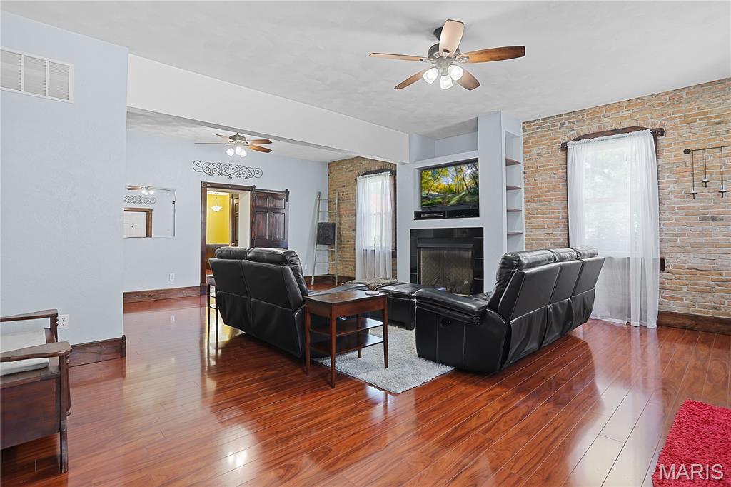 Discover this hidden gem that blends timeless charm with modern updates. Rich engineered flooring and stunning woodwork throughout the home showcase its timeless character, while thoughtful updates provide the comfort and convenience of today's living. The inviting living room features a full wall of exposed brick, a gas fireplace with a blower, and custom built-ins. A Jefferson staircase leads to an upstairs retreat complete with built-in bookcases, a cozy window seat, and abundant storage. Designed with entertaining in mind, this home offers multiple gathering spaces, including a great room off the kitchen and a finished lower level that's perfect for hosting gatherings or game nights. Love to cook? The thoughtfully updated kitchen is sure to impress, featuring an island, a dedicated food prep station, a beverage area, and classic farmhouse sink that combines style and functionality. The updated main level bathroom includes a walk-in shower with a built-in bench that combines comfort and ease. The new three-zone HVAC system provides enhanced comfort and energy efficient climate control throughout the home. Step outside to enjoy the spacious covered patio, complete with a fire pit and a convenient grilling area, ideal for entertaining or unwinding at the end of the day.  The large backyard shed provides ample storage space for a riding lawnmower, golf cart, tools or other outdoor equipment.  You don't want to miss this unique property that has modern elegance, traditional craftsmanship and vintage appeal. Buyer to verify all MLS data prior to making an offer. Schedule your showing today!