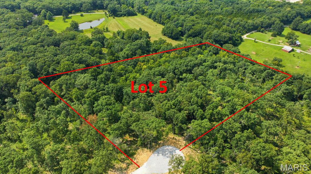 5.27 Beautiful, wooded acres located just minutes from I-70 and conveniently situated just off blacktop frontage. This peaceful property offers the perfect setting to build your dream home or barndominium while enjoying privacy, nature, and easy access to nearby amenities. Lots range from approximately 3 to 5 acres and are subject to minimal restrictions. No mobile or modular homes, junkyards, or hog farms are permitted. Cuivre River Electric will be available upon completion of engineering and installation by the developer. Each lot will require a private well and septic system.