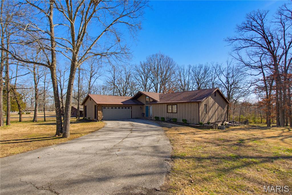 Contemporary ranch situated on 1.2 +/- wooded acres offering approximately 3,500 sq ft of total living space. This versatile home features 4–5 bedrooms and 3 full baths with a flexible layout ideal for family living or entertaining. The main level highlights engineered hardwood flooring, maple cabinetry, and stainless steel appliances. The primary suite includes an updated bath with a tile shower. The fully finished basement expands the living space with three additional bedrooms, a bar area, and dedicated gym space, perfect for guests, recreation, or multi-generational living. Outdoor amenities include a 40’ x 20’ in-ground pool surrounded by mature trees for privacy. A rare opportunity combining acreage, space, and move-in-ready features. Agent Owned