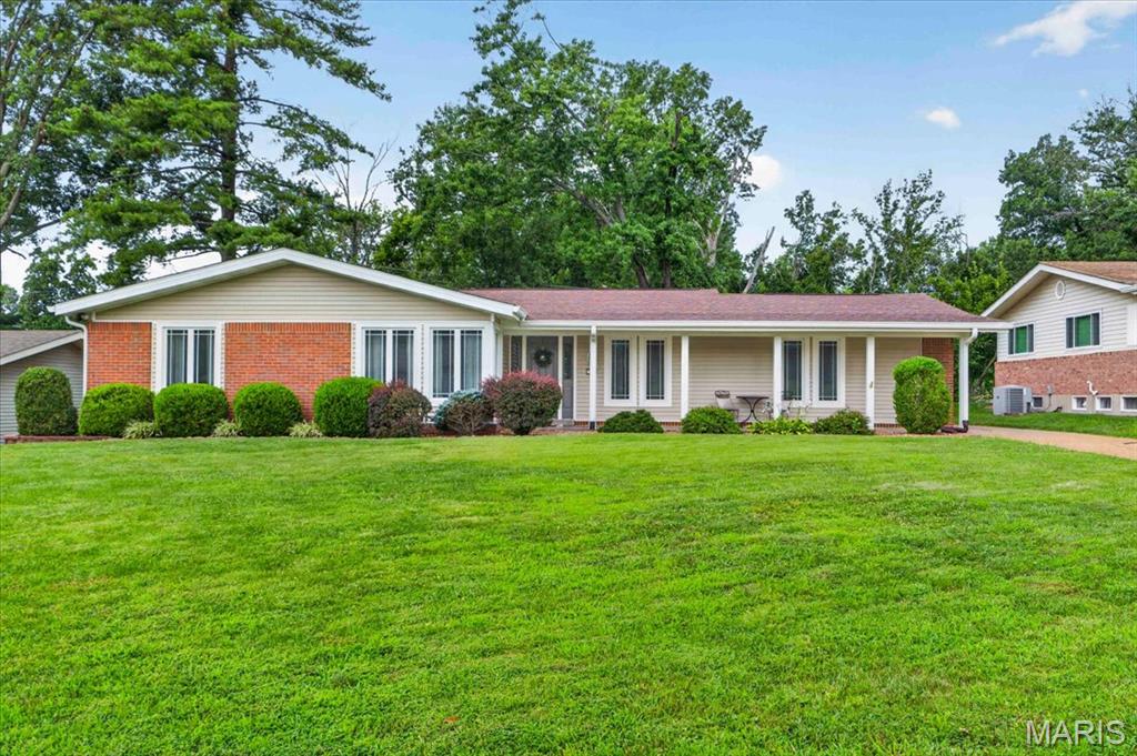 **NOW SHOWING!!** Brick, Beauty, and Ballwin Bliss! Welcome home to effortless single-story living! Nestled on a quiet street backing to common ground, this move-in-ready 3-bedroom ranch offers the ideal balance of neighborhood connection and private retreat. From the moment you arrive, the crisp brick accent exterior, manicured lawn, and broad covered front porch deliver undeniable curb appeal! Step inside to discover a bright, flowing layout accentuated by brand-new overhead light fixtures and stylish engineered wood flooring that seamlessly sweeps through the general living space. The heart of the home, the kitchen, was completely reimagined in 2024, featuring an eye-catching custom accent island, Cambria quartz countertops, and a stylish LVT floor. Whether you’re hosting in the spacious front dining room or enjoying a quiet morning by the fireplace, the abundance of newer, oversized windows ensures every corner is bathed in natural light. Retreat to the primary suite, where a 2021 renovation transformed the bath into a spa-like sanctuary featuring a trendy comfort-height dual vanity and a pristine walk-in shower. Two additional bedrooms boast original hardwoods, adding a touch of timeless character. Beyond the walls, the property backs to peaceful common ground, providing a serene backdrop for your newer concrete back patio (2020). With an oversized 2-car rear-entry garage and a clean FULL BASEMENT, storage and hobby space are plentiful. Adtl peace-of-mind updates include the BRAND NEW HVAC (2025), garage doors & motors (2022), windows (2016), roof/gutters/soffits (2016/2017), electrical panel (2019) & plumbing stack (~ 5 y/o). Perfectly positioned for quick access to Hwy 141, I-40, and Manchester Road, you are minutes from Parkway West High School, Town and Country Crossing, North Pointe Aquatic Center, Vlasis Park & Ballwin Plaza! Schedule a showing today!