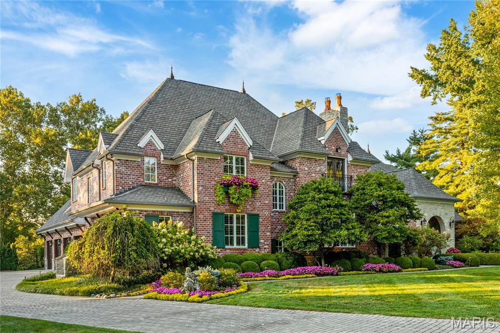 Wide plank hardwoods, timber beams & stone accent walls define the rustic elegance of this magnificent Dick Busch designed European-inspired Estate home. Impressive hardwood foyer leads to formal living room, dining room with 12’ timber beamed ceiling & stone fireplace & spectacular family room highlighted by floor-to-ceiling fireplace. Designer kitchen with custom cabinetry, commercial grade appliances, 9’ center island & butler’s pantry with convenient planning center adjoins gathering bar & wine room. Primary bedroom suite with beautifully appointed bath with shower spa offers an appealing retreat. Hardwood floors continue to the 2nd level with 4 additional bedrooms, 1 with ensuite bath & 2 with Jack n’ Jill bath. A 2nd staircase accesses guest suite & private study. Lower Level includes recreation room, game room, workout room & half bath. Situated on parklike 1.7-ac grounds with covered patio with fireplace, resort style pool, pool house & patio with pergola & full-height fireplace plus 4-car garage.