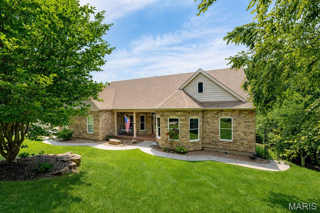 Are you ready for lakefront living? This majestic 4+ bed/3.5 bath stone front atrium ranch is guaranteed to impress! The open floor plan allows you to enjoy the views throughout the home.  The vaulted great room with floor to ceiling stone gas fireplace is open to the dining room and kitchen beyond. The chef in you will delight at this custom kitchen offering ample cabinetry, huge center island with breakfast bar, stainless appliances, walk-in pantry. The kitchen overlooks the inviting breakfast area and walks-out to the wrap-around sunroom and Trex deck with wonderful lake views. Elegant master suite boasts huge his & hers walk-in closets, private sunroom & elegant ensuite bath w/double vanity, walk-in shower & jet tub. The main floor also features a second bedroom with en suite bath & walk-in closet, large den/office with double door entry which could easily be a third main floor bedroom. 
The expansive finished lower level adds a huge recreation room w/tray ceiling, a wall of windows overlooking the lake and stately wet bar with wine cooler, 3rd and 4th bedrooms both with walk-in closets, full bath, private den/bonus room, custom bar and workshop.  Updated large main floor laundry with ample storage and farmhouse sink and 2 exterior storage rooms. Expansive stone landscaping leads to large level area & lake access. The lakeside space with a pebble beach area, fire pit, seawall and boat launch allows for endless enjoyment.