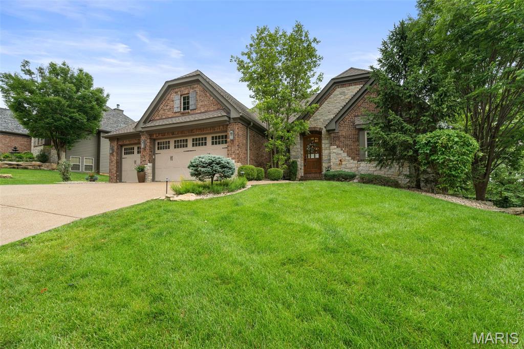 Perched high above the Katy Trail with sweeping, panoramic vistas that stretch for miles, this extraordinary custom ranch offers a lifestyle that feels worlds away, yet is just minutes from Chesterfield and highways. Originally designed as the community’s display home, this one-of-a-kind residence combines exceptional craftsmanship, breathtaking scenery, and effortless luxury in one remarkable setting. The dramatic wall of floor-to-ceiling windows in the great room captures your attention, framing the ever-changing landscape like a work of art. Anchored by a cozy fireplace, this inviting space was designed for both grand entertaining and quiet evenings spent watching the sunset paint the horizon. The open-concept floor plan flows seamlessly into a custom kitchen, thoughtfully appointed for everything from intimate dinners to holiday gatherings. Just beyond, the three season room becomes a natural extension of the living space. Imagine hosting wine tastings with friends as the sun dips below the rolling hills, enjoying morning coffee surrounded by birdsong, or ending the day with a good book while taking in the spectacular views that seem to go on forever. The luxurious main-level owner's suite serves as a private retreat, featuring a spa-inspired bath with a stunning stone walk-in shower, dual vanities, and an oversized walk-in closet. The finished walk-out lower level is equally impressive, offering abundant natural light, a spacious family room, two additional bedrooms, a full bath, and a custom bar complete with a dedicated wine nook—an ideal setting for entertaining guests, celebrating special occasions, or enjoying a relaxing evening at home. Step outside and discover your own private sanctuary. Follow the stone path to a stately fireplace where stories and s'mores await beneath the stars, or unwind in the hot tub after a day spent working, hiking, or cycling along the adjacent Katy Trail. With direct access to one of Missouri’s most beloved recreational destinations, outdoor adventures are always just steps away. Nestled within an exclusive gated community known for its privacy and tranquility, this exceptional property offers a rare opportunity to experience high style living surrounded by nature, spectacular views, and unmatched serenity. If you've been searching for a peaceful retreat without sacrificing convenience, you've found it. Welcome home.