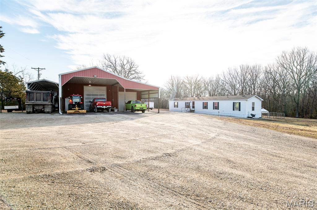 Nestled in a picturesque 3.6-acre country setting just outside the city limits of Belle, this beautiful future building location offers a serene escape. The expansive acreage boasts open, gently sloping, and wooded areas, providing a tranquil environment.

This well-maintained mobile home, a ‘2000 model 16’x80’, features three bedrooms and two bathrooms. It boasts vinyl siding and an approximately nine-year-old shingle roof. A fresh water deep well and a concrete septic tank are already in place, ensuring a reliable water supply and waste management system.

Along with the shop is a 14'Wx50'Lx16'T portable carport large enough for camper storage or just about anything else you would need it for.  In the front of the shop is a 44'Wx24'L covered concrete carport.  

Inside the shop, you’ll find a water filtration and softener that serves both the shop and mobile home. Additionally, there’s a sectioned-off room, currently used as a beauty salon, equipped with its own heat and air conditioning Mini Split.  future(Man Cave!) or (She Shed!).

The shop includes two large garage doors, each measuring 12’x14’ and 12’x11’, providing ample room to accommodate a camper or semi-truck. This unique listing presents endless possibilities for your future endeavors.