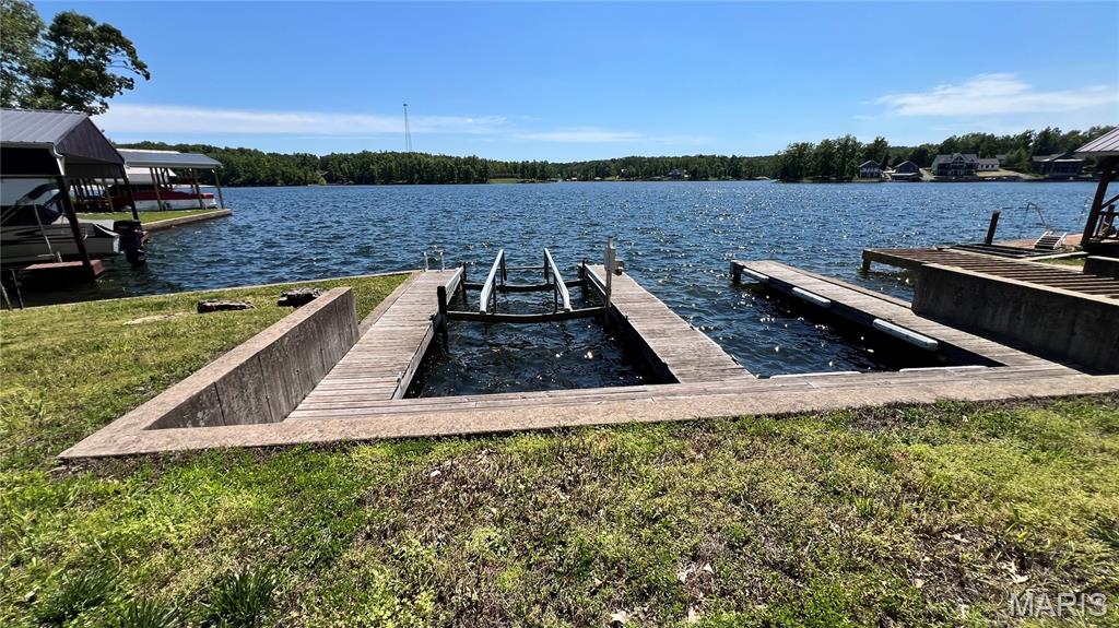 Sunshine and lake breezes come with this sparkling lakefront lot featuring a concrete seawall and two boat slips, including one with a new boat lift installed in 2024 for your convenience. The perfect weekend retreat for your busy lifestyle! Enjoy the beautiful large rock landscaping that enhances the perfect spot to build your dream getaway or camp for the weekend. Sit at your dock and take in the beautiful sunsets — what a perfect way to end your day, enjoying the lake breeze with a cool drink while watching the sun sink below the horizon. This well-maintained lakefront lot is a real treat at this price — there are not many lakefront lots left. Electric and water are already located on the property. Don’t forget all the amenities Lake Perry has to offer: pool, bathrooms, shower houses, laundry area, sandy beaches, playgrounds, fishing, swimming, boating, skiing, marina area, on-site food truck during the summer season, and so much more. This is a rare opportunity you won’t want to miss.