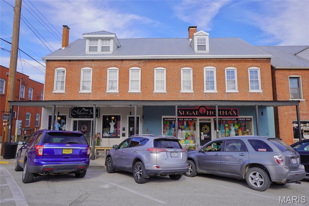Incredible and Rare opportunity to own a beautifully restored, income-producing historic landmark in the heart of Historic Hermann! Built around 1880, this impressive 2½-story brick building offers multiple revenue streams and a prime downtown location just steps from Hermann’s shops, restaurants, wineries, and attractions.
Extensively updated in 2020, the property features new electrical service and wiring, plumbing, bathrooms, water heaters, water softener, HVAC systems, a metal roof, stonework, third-floor vinyl windows, and a spacious composite deck. A rear main-level addition was completed in 2023, further enhancing the property’s functionality and appeal.
The building includes three retail spaces—two leased storefronts on the main level and one second-floor studio currently occupied by the owner, each with its own half bath. The second floor also features four established short-term rental guest suites, operating as The Artist Suites, each with a private full bath. The third floor offers a loft apartment that is currently leased, providing yet another reliable income source.
Additional highlights include a stone storage building, off-street parking for six vehicles with convenient alley access, and an unbeatable downtown location in one of Missouri’s premier tourist destinations.
Whether you’re looking to expand your investment portfolio or own a turnkey mixed-use property with proven income potential, this one-of-a-kind Hermann landmark is an opportunity you won’t want to miss!