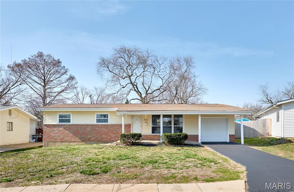 This beautifully updated ranch home in Hazelwood is just waiting for its new owners! You’ll have great curb appeal with a brick front and covered porch. Inside, the vaulted living room is full of natural light, with new luxury vinyl plank flooring and a plant shelf that continues into the dining room. You’ll love the wainscoting, integrated lighting, and wall sconce. The kitchen features granite counters, white cabinets, and stainless steel appliances. The primary suite is a retreat with an updated bath, complete with a large vanity, new floors, and a tile-surround tub. Three more bedrooms and another full bathroom rounds out the main level. The unfinished basement provides storage space and laundry hook-ups. The one-car garage adds even more storage, and has its own entrance to the backyard, making stowing lawn tools a breeze. Enjoy the spring weather on the covered patio overlooking the fenced backyard, shaded by trees. Updates include new roof ('24), windows ('24), bathrooms ('24), siding ('26), and flooring ('26). You’ll be just moments from Howdershell Park and Hazelwood Schools, with quick access to I-270 and all of the restaurants and shopping along Lindbergh Road. Don’t miss out on this one!