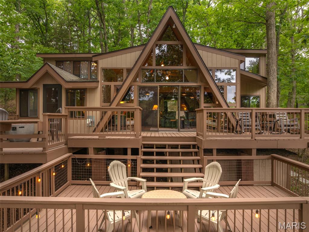 Welcome to 410 Scheffborg Circle Drive, an inviting chalet nestled beneath towering oak trees in a peaceful area of Innsbrook Resort. Designed for making lasting memories, this fully furnished 3-bedroom, 2-bath chalet is ready for you to start enjoying from day one. The expanded kitchen offers abundant counter space, plenty of storage, and a breakfast bar where family and friends can gather while meals are being prepared. Just beyond the kitchen, the large dining area features space for a sizeable table, making it the perfect setting for game nights and family meals after a day on the lake. The vaulted living room serves as the heart of the chalet with soaring ceilings, a pellet stove for year round comfort, and a striking accent wall. Large windows bring in natural light and showcase views of the surrounding trees and lake. The spacious primary suite is conveniently located on the main level and features direct access to a cozy three-season room, creating the perfect spot to enjoy a morning cup of coffee or unwind at the end of the day. Upstairs, you'll find two generously sized bedrooms, a full bathroom, and a huge loft that provides flexibility. There's plenty of room for bunk beds, additional sleeping space, a desk area, a game room, or a hangout spot for kids and guests. Outdoor living is where this property truly shines. The massive multi-level deck offers ample space for entertaining, dining, grilling, enjoying drinks with friends, or gathering around for s'mores under the stars. Huge mature oak trees provide fantastic shade during the summer months while framing beautiful views of the lake. Follow the path down to the brand-new dock where you can fish, swim, launch a paddleboard, or simply relax by the water. The community beach is located directly across the lake, making it easy for kids and grandkids to enjoy swimming, playing in the sand, and jumping from the floating swim dock. *The chalet overlooks a lake that is currently lowered as part of a scheduled Innsbrook Owners Association dredging and lake improvement project. This important maintenance helps preserve the long-term health and enjoyment of the lake. The work is expected to be completed soon, and with normal rainfall, the lake will return to its full beauty. Offered mostly furnished with only a few exclusions, this chalet is truly move-in ready. Cannot be a full time residence or a rental property. Pack your clothes, stock the refrigerator, and start enjoying everything Innsbrook has to offer. Whether you're spending weekends on the water, hosting family gatherings, or simply escaping the pace of everyday life, 410 Scheffborg Circle Drive is ready to become your family's favorite getaway for years to come.