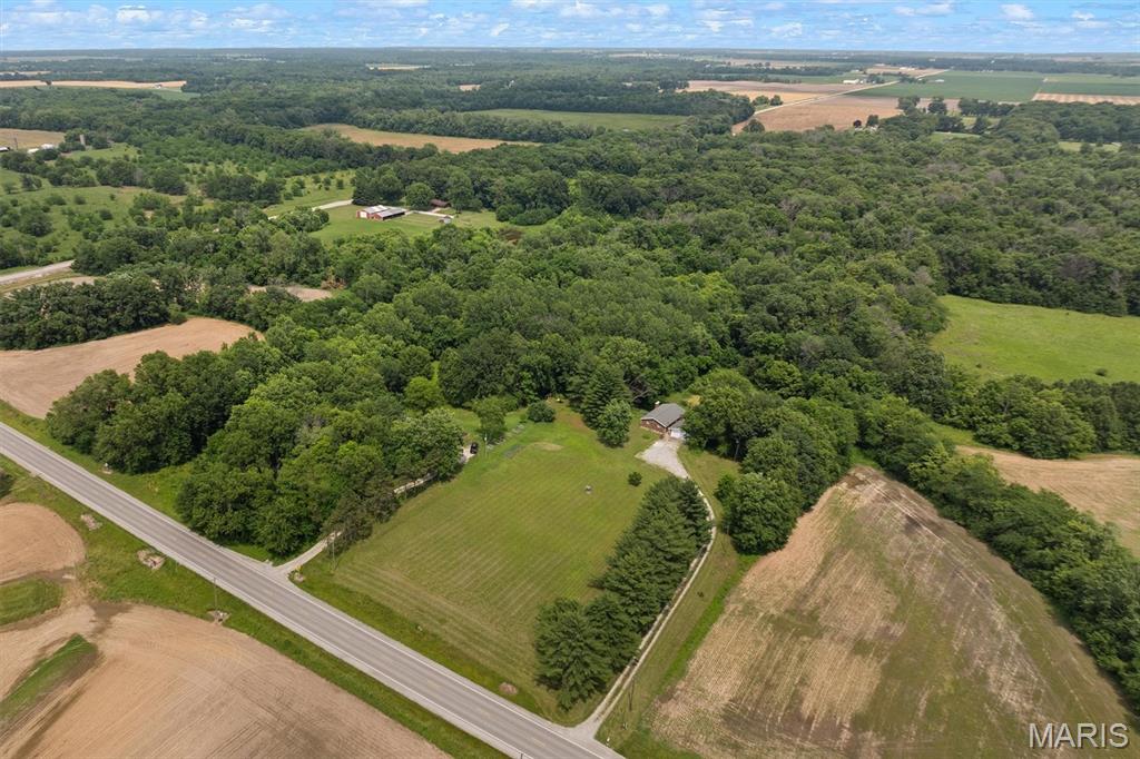 We have what you've been seeking! 14.2 acres in Edwardsville school district not in a subdivision!  Lovely 14.2 acre wooded site with a pond includes a 3 br/3 ba brick ranch with full walkout basement facing the pond and wooded acreage.  Detached brick two car garage.  Home has a lower level and main floor kitchen areas and two brick wood-burning fireplaces.  Main floor living room has built-in bookcases surrounding the fireplace.  Many of the home's floors are professionally installed ceramic tile.  Main floor bath has a step-in ceramic tile shower.  Lower level walks out to the lovely patio and upper level walks out to deck - both overlooking the acreage and pond.  This home is in an estate and is being sold as-is.