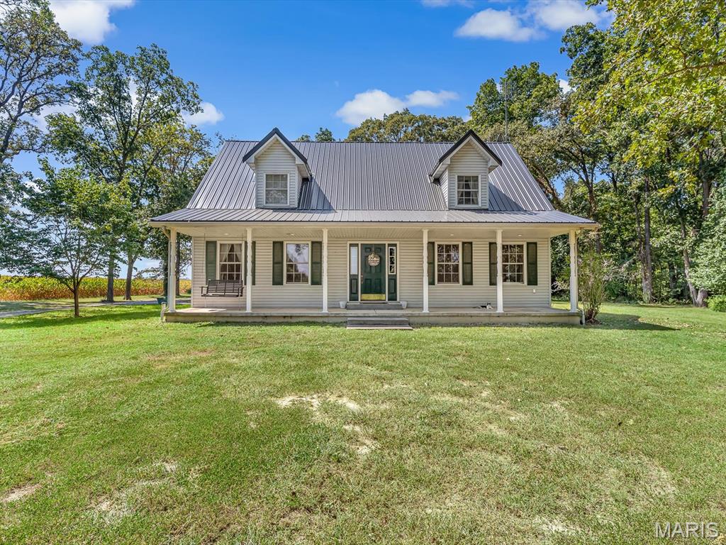 Welcome to this inviting modern farmhouse, built in 2001 and surrounded by peaceful country scenery. A full-length front porch, a metal roof installed in 2026, and a spacious rear patio create the perfect setting for relaxed indoor-outdoor living. The main residence offers three generously sized bedrooms, two full bathrooms, and one half bath. The main-level primary suite features a private bathroom with a walk-in shower and double-sink vanity. Upstairs, two spacious bedrooms with dual closets share a full bathroom with a tub/shower combination. The kitchen is equipped with a gas range, refrigerator, dishwasher, double sink, pantry, and center island, which may remain with the home. Additional highlights include a large dining area, comfortable living room, oversized drop zone or breezeway, and main-level laundry.A finished loft above the garage offers flexible space for guests, recreation, a home office, or an additional living area. It includes a full bathroom, sink, refrigerator, cabinetry, closet, mini-split system, and durable luxury vinyl plank flooring. Outside, the property features a spacious rear patio, multiple outdoor water spigots, and an impressive 30-by-50-foot pole barn. Equipped with electricity and a large main door, the barn provides abundant space for equipment, storage, hobbies, or a workshop. A whole-house water filtration system adds everyday convenience. With abundant space, useful outbuildings, and versatile living areas, this well-appointed country home is ready to welcome its next owner.