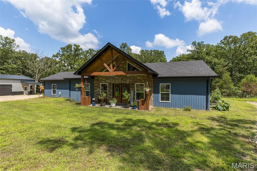 Built in 2025, this modern-country retreat sits on 10 private acres just over the Washington County line and blends new-construction quality with peaceful acreage living. The main home offers 2 large bedrooms, 2 full baths, and a stunning open living area with cathedral ceilings, oversized windows, and beautiful natural light. The kitchen impresses with custom cabinetry, granite countertops, pot filler, pots & pans drawers, SS appliances, and a walk-in pantry featuring cabinetry and countertop space for small appliances. The primary suite includes a large walk-in closet and a spa-like bath with dual sinks and an extra-large walk-in shower with seat and multiple shower heads. Enjoy multiple outdoor living spaces: a covered front porch, covered back patio pre-wired for an outdoor kitchen, and a side patio perfect for a future hot tub. Home also includes instant hot water heater, water softener, whole-house filter, and the living room TV stays—couch may stay as well. A major bonus is the 30x50 outbuilding, fully spray-foam insulated with concrete floors, separate electric meter, and 3–4 car parking PLUS a heated & cooled 1-bed/1-bath living quarters—ideal for guests, hobbies, or income potential. Main home also features a 2-car garage. Property includes a peaceful dry creek at the back, beautiful acreage, and room to expand. A rare blend of new construction, acreage, and multi-use outbuilding—this one checks every box and is ready to impress.