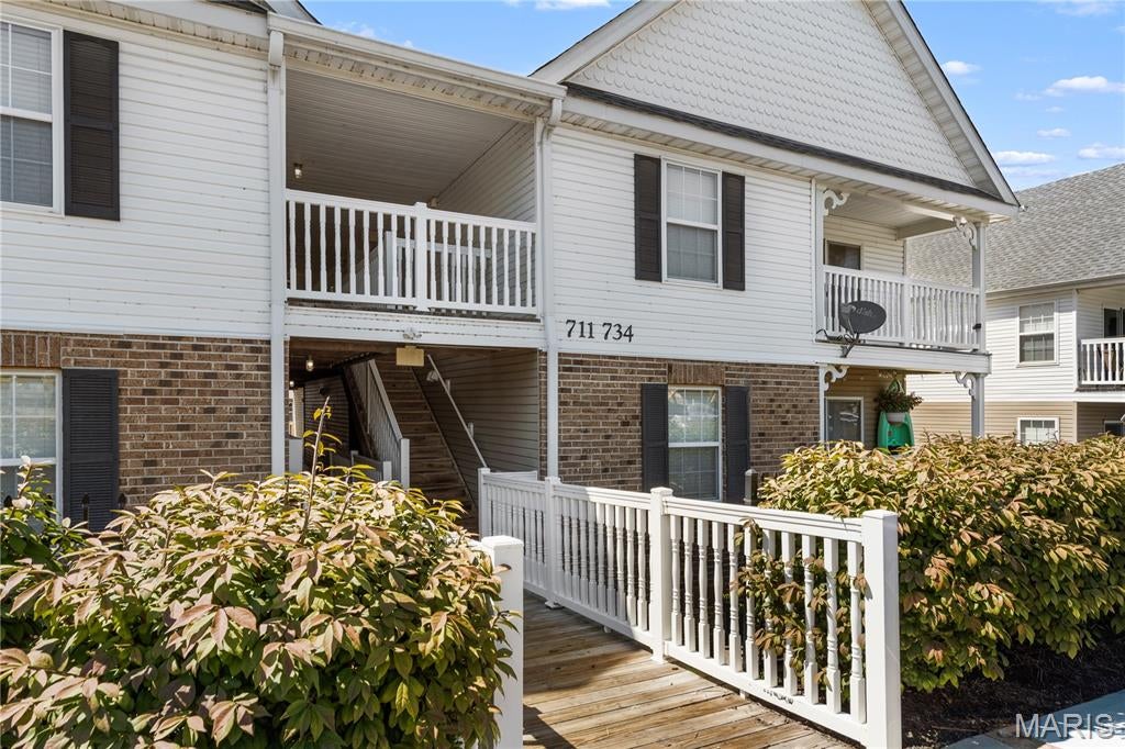 Upper unit carefree condo with VAULTED OPEN FLOOR PLAN, in quiet Bella Vista community tucked behind historic 65-acre farm in St Peters. Elegant 3-story building with 2nd floor entrance, brick detail, vinyl siding, scallop and scrollwork accents. Covered entry welcomes you inside to SOARING CEILINGS and wonderful natural light. Open dining/kitchen with HARDWOOD FLOORING, breakfast bar peninsula, upgraded 42" maple cabinets, tile backsplash, smooth-top range and refrigerator stays. Accent display ledges and pendant lighting throughout. Airy living room with ceiling fan and sliding door to private COVERED DECK with sunrise views - ideal for container gardening. Convenient outdoor storage closet. VAULTED PRIMARY SUITE with ceiling fan, WALK-IN CLOSET and full bath. Secondary bedroom, hall bath with tub/shower combo, and PRIVATE LAUNDRY - washer and dryer stay. Relax every weekend with no exterior chores; plus the association covers water, sewer and trash. Stay fit with the Spencer Creek WALKING TRAIL just a block away. Close to 1200 acres of parks, 3 pools, pickleball, sports, lakes, fishing, 30 miles of trails and more. Easy access to Highways 94/364, with most daily errands within a mile.