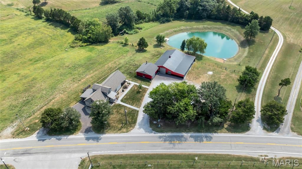 A truly unique opportunity offering the perfect combination of beautifully renovated living space and incredible multi-use potential! This completely renovated farmhouse has been thoughtfully updated from top to bottom, including new electrical and plumbing, windows, doors, flooring, lighting and stylish farmhouse-chic finishes throughout. The main level welcomes you with a vaulted foyer and an impressive floor-to-ceiling stone gas fireplace. The beautifully updated kitchen features granite countertops, a distressed wood-style island, ceramic tile backsplash, walk-in pantry and stainless steel KitchenAid appliances.

The main-floor primary suite offers a bay window, private bath with walk-in ceramic tile shower and rainfall showerhead, plus a walk-in closet conveniently connected to the utility room. Additional living space includes a finished lower level with a full bath and abundant storage, while the upper level provides additional sleeping space, a bath and play/recreation area.

Outside is where this property truly sets itself apart. Enjoy the covered patio overlooking the pond and partially fenced grounds, plus an enormous outbuilding offering exceptional flexibility for a workshop, office, equipment or vehicle storage, business operations and more. The building features multiple overhead doors, an RV-height bay, bathroom, large lean-to, rear patio doors and separate electrical service.

With commercial/light industrial use potential, this one-of-a-kind property offers an uncommon opportunity to combine home, business, recreation and storage all in one location. Whether you're looking for room to operate a business, house equipment, pursue a hobby or simply spread out, this property delivers possibilities that are incredibly hard to find!