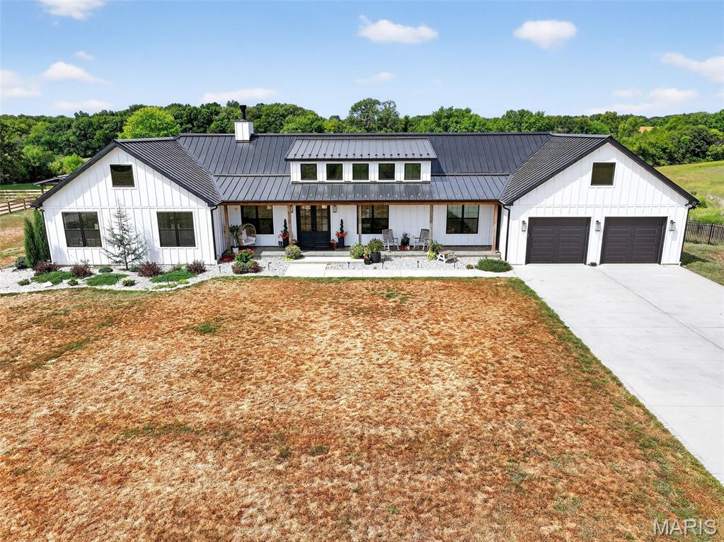 Experience the beauty of country living on just over 41 acres with this breathtaking property, designed with both comfort and equestrian lifestyle in mind. Along with partial private lake ownership, you’ll find a 50x100 barn complete with horse stables, a partially fenced yard, and an outdoor riding arena ready for training or leisure rides. The land also offers a stocked lake, zip line, and deer stand—and with landowner hunting tags, you’ll have the opportunity to enjoy your own private hunting grounds right at home.

The expansive covered back patio, featuring stamped concrete, ceiling fan, and a striking stone fireplace, overlooks the water and creates the perfect gathering space after a day spent outdoors with your horses. Step inside to an inviting open floor plan where a chef’s kitchen with quartz counters and a massive island flows seamlessly into the dining area and living room with fireplace.

The split-bedroom layout includes a luxurious primary suite with gas fireplace and deck access, while four additional bedrooms, two full baths, and a laundry room with dog shower provide everyday convenience. A walk-out basement, with rough-in for a wet bar and egress windows ideal for a second suite, awaits your finishing touch. Horses and livestock are welcome here. *Potential to negotiate and split acreage.