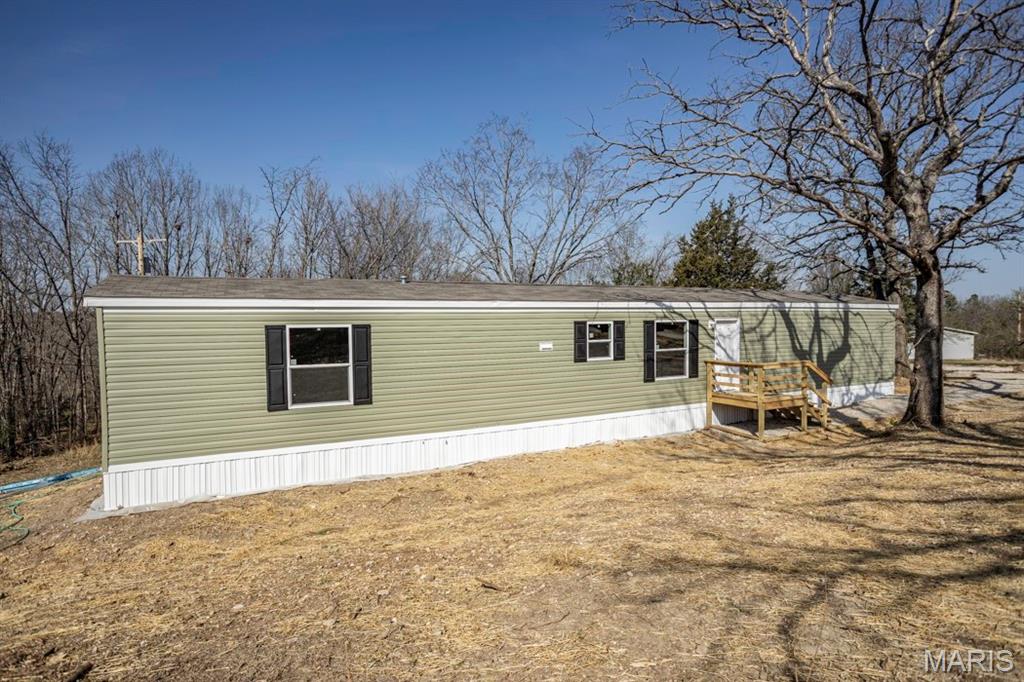 Welcome to this brand new 3 bedroom, 2 bathroom manufactured home offering modern style and low-maintenance living in a convenient location. Step inside to a bright, open-concept layout featuring a seamless flow between the living, dining, and kitchen areas, perfect for everyday living and entertaining. The kitchen is equipped with a breakfast bar, pantry, and sleek finishes that complement the home’s neutral, modern color palette. The split bedroom floorplan provides added privacy, with a spacious primary suite that includes great closet space and a private bath. Enjoy the durability and easy upkeep of laminate flooring throughout, no carpet! This home also includes a 1-year manufacturer warranty, 5 year manufacturer warranty on appliances, 30 year manufacturer warranty on the roof, 20 year manufacturer warranty on the siding, providing added peace of mind for the new owner. Ideally located just minutes from the front gates of Fort Leonard Wood and close to downtown Waynesville, this home offers both comfort and convenience.