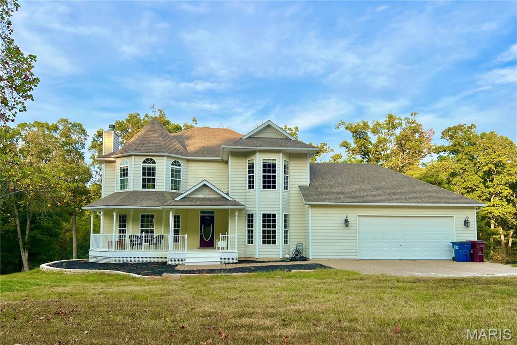 This Victorian style welcomes you through the covered front porch into the Great room that boasts a wood burning fireplace and windows across the back of the home with a view of the lake/pond.  Home has 3 Bedrooms on upper level and a room for an office/sewing room/gun room in lower level. Sits on 7 acres. 2 1/2 baths on main level and up, 1 full bath on lower level. Great room opens up to the breakfast room and kitchen which wraps around the formal dining room.  Customed cabinets in kitchen gives you lots of countertop space and cabinets for storage and a walk-in pantry.  Main level laundry. Wood floors.  Primary suite has vaulted ceiling, large walk-in closet and primary bath has separate tub and shower. Jack and Jill bathroom between additional bedrooms on 2nd floor that have been painted a nuetral color. Zoned heating/cooling to keep each level at the temperature needed. Boasts crown molding throughout first level of home. Walk-out basement contains a recreation room and bar with refrigerator and office room with its own exterior door and bathroom. 2 car garage attached to house and additional garage below garage on lower level. Don't forget the temperature controlled detached garage 41 x 60 with 2 walk-in doors and 2 drive through overhead doors, with openers. Detached garage has hot water heater, sink and toilet, workbench area, it's a dream come true. Lean to off North side of garage and concrete to park your boats, trailers, RV's, etc. Wild Horse Farms Subdivision gives you rights to a 20 acre community lake. All this sits on 7 Acres. Washer,dryer, basketball hoop do not convey.