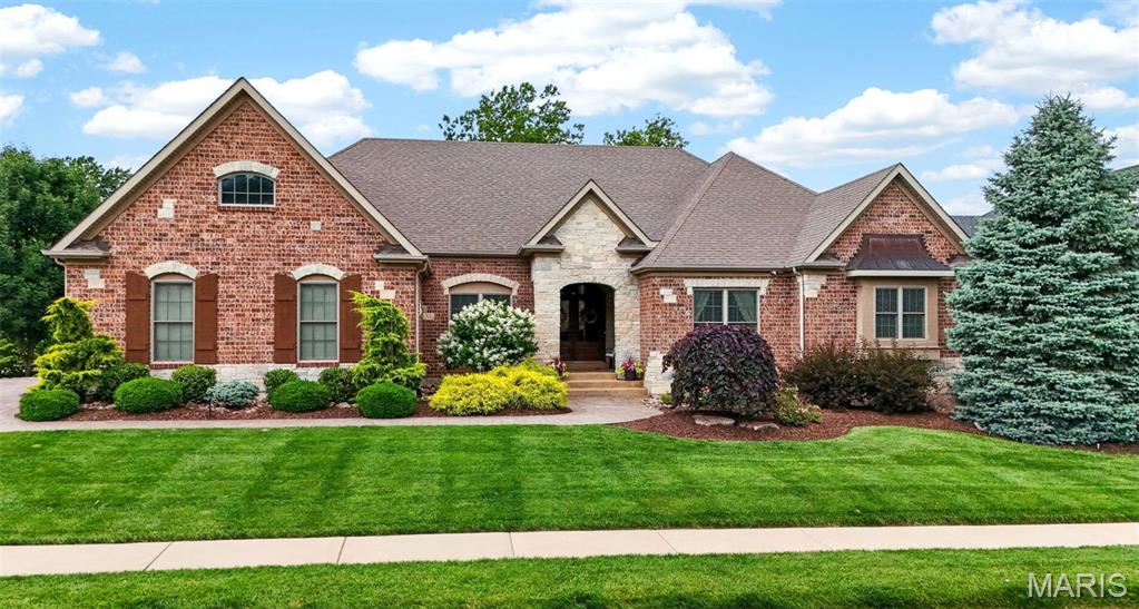 Situated on a beautifully landscaped half-acre lot, this exceptional walkout ranch offers over 6,200 square feet of finished living space, combining timeless architecture, outstanding craftsmanship, and resort-style outdoor living.
From the striking brick and stone exterior and incredible Pavestone driveway to the meticulously maintained grounds, this home makes an unforgettable first impression. Inside, engineered hardwood flooring, soaring 12-foot ceilings, and three floor-to-ceiling masonry/stone fireplaces create warmth and elegance throughout the main level. The thoughtfully designed floor plan includes a private study, formal dining room, inviting hearth room, expansive great room, and convenient main-floor laundry.
The chef's kitchen is designed for gathering, featuring granite countertops, upgraded stainless steel appliances, a gas cooktop, double wall ovens, abundant custom cabinetry, and an oversized semi-circular breakfast bar. The adjoining breakfast room opens through a 9’ atrium slider to the incredible, covered screened porch, creating seamless indoor-outdoor living.
The luxurious owner's suite offers a tray ceiling, bay window, spacious walk-in closet, and a spa-inspired bath with dual vanities, custom cabinetry, a corner soaking tub, and an oversized tiled shower with frameless glass enclosure. Additional bedrooms are generously sized and served by a Jack-and-Jill bath, while two powder rooms provide added convenience for guests.
The walkout lower level is truly extraordinary. This 2,500-square-foot space showcases custom wood doors, stone walls, arched openings, and exceptional craftsmanship throughout. Entertain with ease around the custom wet bar featuring a reclaimed wood bar top, stone accents, dishwasher, ice maker, and wine refrigerator. A dramatic arched stone entry leads to the private wine cellar, while the full second kitchen and expansive gathering areas make this level ideal for hosting family and friends.
Outside, a true private backyard oasis awaits! Enjoy the heated Gunite pool, covered patio, covered screened porch, multiple paver patios, masonry fire pit, expansive lawn, and numerous seating areas designed for relaxation and entertaining. Whether hosting a crowd or enjoying a quiet evening by the fire, this outdoor retreat delivers an exceptional lifestyle.
Additional features include an oversized 3-car garage, dual HVAC systems with conventional heat pumps, dual water heaters, irrigation system, 4 bedrooms, 3 full baths, and 2 half baths. Luxury, craftsmanship, and unforgettable indoor and outdoor living await!