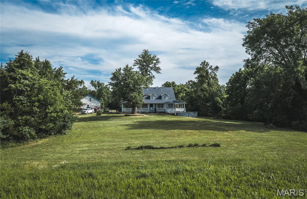 Perched atop a gently sloping hill with sweeping views across nearly the entire property, this 69.45 +/- acre Franklin County gem offers the perfect blend of country living and convenience — just 10 minutes from Union and less than 10 miles from Washington with easy access to Hwy 50. The 2,278 sq ft two-story home features a main floor master bedroom, hardwood floors, a gas fireplace surrounded by custom built-in bookshelves, and a kitchen with custom cabinets and new quartz countertops. Two bedrooms and a full bath upstairs, plus a walk-out basement with a kitchenette and fourth bedroom — perfect for guests. Bay windows in the living room frame the landscape beautifully, and the covered wrap-around porch offers one of the most stunning hilltop views in the area — the kind of view that makes this property truly unforgettable. The 51x29 garage with a loft, concrete floors, and electricity handles all your storage and hobby needs. The nearly 50 acres of terraced open ground was recently used for hay and CRP and could easily be turned back into a productive ranch or horse property. The remaining 20 acres of timber provides excellent habitat for deer and turkey. Whether you're searching for a forever home, a working farm, or a recreational retreat close to town, this property delivers on every front. An additional adjoining 54 acres is also for sale. Don't miss this rare opportunity.