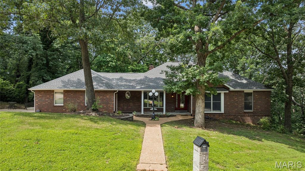 ** Price Reduced**Custom-built ranch on 1.17 wooded acres in unincorporated Jefferson County, offering exceptional privacy on a quiet private country circle with only three homes. Ideally located between Fenton and Arnold, this peaceful retreat combines a secluded setting with easy access to shopping, dining, and everyday conveniences.
The inviting covered front porch welcomes you into an open floor plan featuring formal living and dining rooms, a vaulted great room with a stunning two-sided see-through fireplace, and French doors leading to a maintenance-free Fiberon deck overlooking the wooded lot. The oversized updated kitchen includes abundant cabinetry, a bay-window breakfast area, and a second set of French doors to the deck. Main-floor laundry with washer and dryer leads to the oversized three-car side-entry garage.
The main level offers three spacious bedrooms, including a luxurious primary suite with a fireplace, bay-window sitting area with soaker tub, separate shower, double vanity, and walk-in closet. The finished walkout lower level features a large family/rec room with numerous windows, access to a private deck, a fourth bedroom, full bath, and flexible space perfect for guests, a home office, or recreation.  As a bonus, there is also a large walk-in cedar closet.  Offering oneyear home warranty.
Recent updates include a newer roof, front entry door, kitchen, and beautiful wood flooring. Enjoy custom craftsmanship, scenic wooded views, and a prime location with quick access to Hwy. 141, shopping, dining, and everyday conveniences.
Swim Spa not included.
