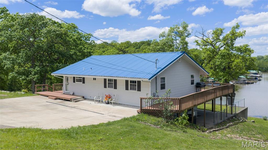 Enjoy lakefront living at its best in this beautifully remodeled 4-bedroom, 2-bath home tucked into a peaceful, quiet cove at the 93 mile marker. This property features a fully finished walk-out lower level, offering plenty of space for family and guests. The updated kitchen boasts brand-new granite countertops and all new appliances, while the lower level has been refreshed with new carpet. The home also includes a metal roof and a water softener installed just one year ago. Outdoor enthusiasts will love the impressive dock setup with 3 wells and three 29x40 slips, plus a swim dock—perfect for enjoying the lake all season long. The property also includes a spacious 24x38 shop with electricity that can accommodate up to four vehicles, a carport, and an additional storage shed for all your extras. Surveyed and well-maintained, this property offers the ideal blend of comfort, functionality, and lakefront lifestyle. Whether you're looking for a full-time residence or a weekend retreat, this one checks all the boxes. Call for a private showing today!