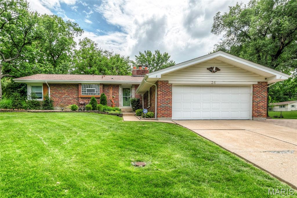 Welcome to 26 Rolling Hills Drive, an Award-Winning Beauty in Black Jack, MO!  Set in a small subdivision of huge lots and sturdy homes, this outstanding full-brick home with 3BR/2BA/2-Car Garage/MAIN FLOOR LAUNDRY/2 Fireplaces/Finished LL/Deck/Paver Patio on a huge, nearly half-acre, corner, fully landscaped and hardscaped lot, plus shed, is a rare find.  Beautiful wood shutters flank all windows and doors.  Landscaped sidewalk leads to pretty leaded glass front door with full view storm door.  Foyer has doorbell chime niche, ca. 1955, and opens to Family Room with coved ceilings, nicely trimmed woodburning fireplace with glass doors, and huge picture window.  Family Room/Dining Room/Kitchen are nice and open here.  This kitchen is one to love.  It features staggered, raised panel cabinetry with pulls, topped with multipiece crown molding.  Very pretty.  Quartz countertops, coordinating tile backsplash, pantry, recessed lighting, ceiling fan, gleaming engineered hardwoods, PLUS separate cabinetry buffet in dining area.  Refrigerator stays!  Big Dining Room with coved ceiling, more gleaming engineered hardwoods, and ceiling fan has slider that leads to large composite deck (16 x 16) with iron railing that steps down to the yard.  Also on this side of the house is a magnificent paver patio with built-in firepit.  Every inch of this home has been lovingly updated, inside and out!  Heading back inside, the Main Floor Laundry is just off kitchen and also opens to Foyer -- washer and dryer stay.  Hall bath has been refreshed, and it's a beauty:  Adult-height vanity and commode, tall tub, beautiful tile surround and new flooring.  Six-panel doors throughout, and nearly everything on main level has fresh paint.  New carpeting in all bedrooms, including nice-sized Bedrooms 2 and 3.  Ceiling fans in all bedrooms.  Primary bedroom features corner windows and an ensuite full bath with bright, glass-block windows, lots of counter and cabinet space, and shower.  Heading down to the finished LL, we have a second family room with a stone, woodburning fireplace with raised hearth.  Wood covered beams, wood bar, and wood accents give this space a wonderfully cozy and comfortable feel.  Large tiled area perfect for crafts or card games, and storage/utility area rounds out the LL.  Every side of this home has been landscaped, and the back is as pretty as the front!  Sellers are offering a Choice Ultimate Home Warranty for the new owners.  Make your appointment to see this one today!