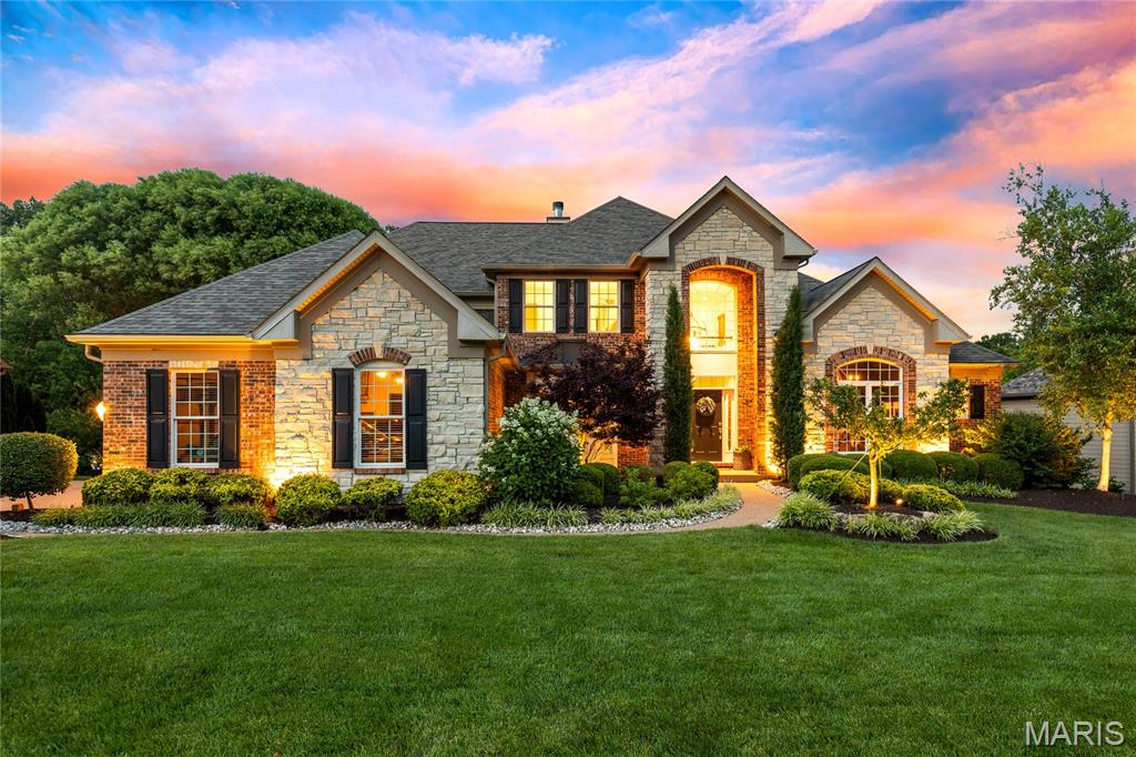 A rare opportunity to own one of Austin Ridge's most celebrated residences, this spectacular Arbor-built estate masterfully blends timeless architecture, exceptional craftsmanship, and designer-curated interiors. Situated on a private 1.2-acre wooded homesite, the home offers an unparalleled lifestyle defined by elegance, comfort, and sophistication. A breathtaking two-story foyer with a grand flared staircase introduces exquisitely appointed living spaces, including a private executive study, formal dining room with architectural archways, and a magnificent great room anchored by a marble see-through fireplace, custom built-ins, and a soaring wall of windows showcasing tranquil woodland vistas. Designed for both everyday living and grand-scale entertaining, the chef's kitchen is a masterpiece featuring bespoke white cabinetry, an oversized quartz island, premium JennAir appliances, massive walk-in designer pantry, and seamless flow into the light-filled breakfast room and inviting hearth room with a dramatic floor-to-ceiling brick fireplace. Expansive glass doors open to the covered lanai, creating a seamless indoor-outdoor living experience. The luxurious main-level owner's retreat offers refined comfort with a coffered ceiling, stunning custom built-in, elegant bay window, and spa-inspired bath featuring dual vanities and exceptional finishes. Upstairs, three generously sized bedrooms provide exceptional comfort and privacy, including a private ensuite and a Jack-and-Jill arrangement. Both second-floor bathrooms have been extensively remodeled with designer finishes, premium fixtures, and timeless selections, elevating the home's already impressive level of luxury and craftsmanship. The walk-out lower level rivals the finest custom homes, featuring floor-to-ceiling windows, site-finished oak flooring, an expansive family room, a custom Liston-designed gathering bar, guest suite, additional laundry facilities, and powder bath—creating the ultimate destination for entertaining and extended-stay guests. Surrounded by professionally designed landscaping from Chesterfield Valley Nursery, the outdoor living spaces include a covered lanai, expansive patio, and peaceful wooded backdrop. A spacious three-car garage completes the offering. Widely recognized as a designer showcase residence, this extraordinary Arbor-built home has been featured in St. Louis Homes Magazine, Ladue News, and the St. Louis Post-Dispatch—a testament to its exceptional design, enduring quality, and distinguished presence within one of the area's most sought-after communities.