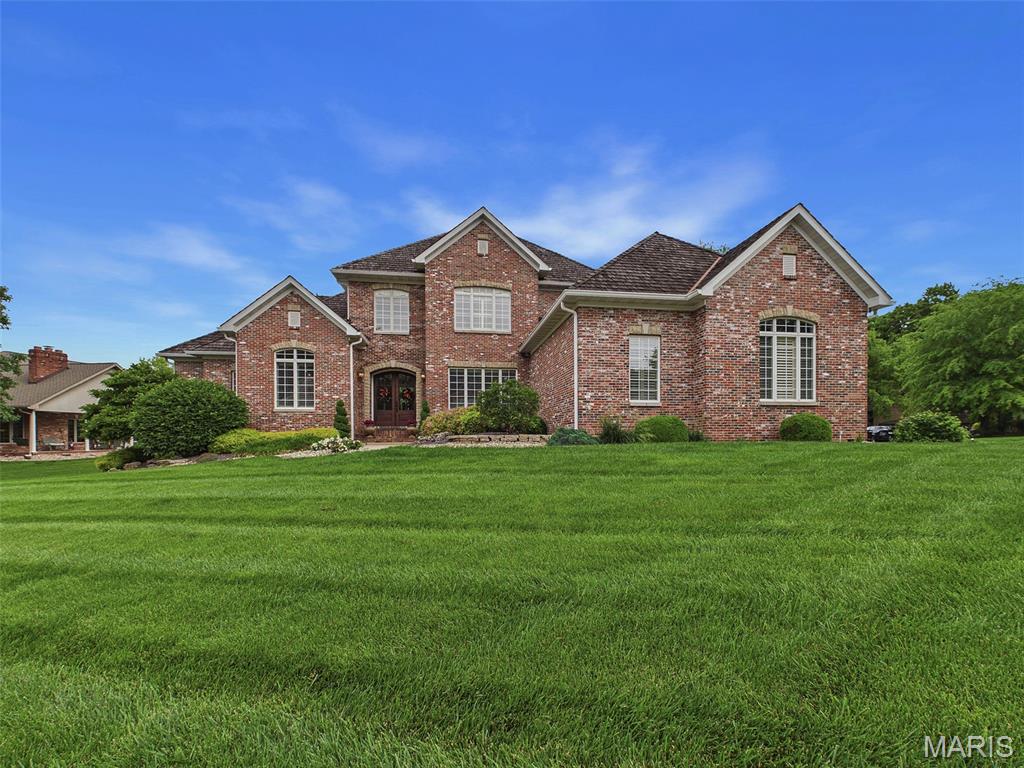Exceptional all-brick 1.5-story estate showcasing timeless elegance, luxury finishes, and impeccable craftsmanship throughout. From the moment you enter through the arched double mahogany doors, you’re welcomed by soaring architectural details, transom windows, rich hardwood flooring, travertine tile, and refined custom design at every turn.

Designed to impress, the gourmet chef’s kitchen serves as the heart of the home and features custom Herzog cabinetry, marble and butcher block countertops, Wolf gas range with pot filler, a built-in Sub-Zero refrigerator, prep sink, oversized center island, and premium finishes perfectly suited for entertaining and everyday living alike.

The breathtaking hearth room offers vaulted ceilings and a dramatic floor-to-ceiling stone fireplace. The luxurious primary suite is a true retreat, complete with a grand entry, spacious sitting area, spa-inspired bath, and expansive his-and-hers walk-in closets.

The professionally finished lower level is designed for entertaining on every scale, featuring a private gym, additional bedroom, stunning wet bar, spacious family room, home theater, and recreation area.
Additional highlights include 3-zoned HVAC systems, whole-home speaker and alarm systems, an irrigation system, and countless custom upgrades throughout. 

This extraordinary residence seamlessly blends comfort, sophistication, and functionality into one remarkable home.