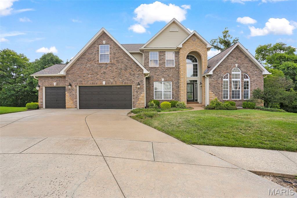 Open and spacious 1.5 Story Home in a great Lake St Louis Location.   4 bedroom with main floor primary BR, 3 Full, 2 Half bath home with over 5,000 of finished living space.   2 story entry foyer with living room/office and dining room on either side, great room with gas fireplace opens into the breakfast room and kitchen with walk in pantry, center island and plenty of cabinet and counter space and hearth room with gas fireplace.  Wall of windows along the back of the home overlooks the almost 1/2 acre tree filled lot.   Screened in porch and deck off the breakfast room.  Primary main floor bedroom with huge walk in closet and luxury primary bathroom with separate jet tub and shower.  2nd floor with loft area and 3 good sized bedrooms, 2 with jack n jill bath and 3rd with it's own full bathroom.   The finished walk out lower level has a wet bar, 1/2 bath, huge rec room and plenty of storage space.  Other features include zoned HVAC, 3 car garage, 2-tiered decks, main floor laundry and so much more.