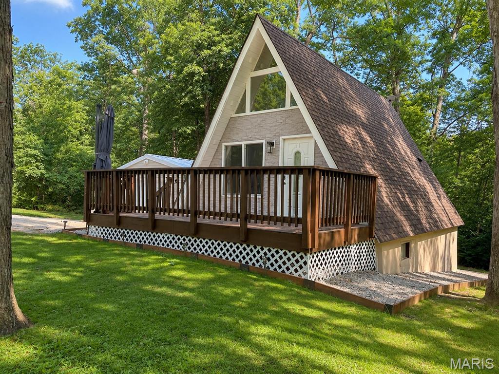 Escape to your own private retreat with this charming A-frame tucked among the trees in Lake Arrowhead. Situated on four parcels totaling approximately 1 acre, this unique property offers soaring vaulted ceilings, a wall of windows that fills the living room with natural light, and the character that's hard to find in today's homes.

The main level features an open living area, updated flooring, a full bathroom, and an upper-level sleeping area. Downstairs, the finished walkout lower level adds valuable living space with a finished sleeping area with an adjoining full bathroom, currently used by the seller as the primary sleeping quarters.

Major improvements completed during the current ownership include a new HVAC system, all new ductwork, new water heater, updated electrical panel, new flooring throughout, a finished lower level, retaining wall, and replacement rear exterior door. The oversized detached garage has also been expanded and updated with a new roof, new siding, and its own electrical panel.

Whether you're looking for a full-time residence or a weekend getaway, this one offers the privacy, character, and updates you've been searching for while enjoying the amenities of the Lake Arrowhead community.
