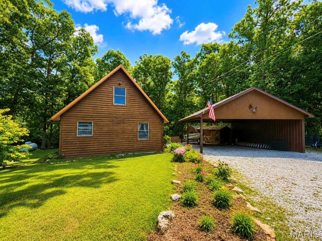 BEAUTIFUL CABIN AT MARK TWAIN LAKE! Whether you are looking for a weekend getaway or a full-time residence, this is the perfect lake property! This 3 bed, 1 bath cabin features beautiful pine tongue & groove throughout, with a bright and open living space. Master is on the main level, with two large bedrooms upstairs. BBQ and relax after a day on the water, on the deck overlooking the private wooded back yard. This property also features covered parking perfect for boat storage, jet skis or a side by side. Two storage sheds give you plenty of space for your mower and all your extra items. Brand new copper metal roof and cedar fencing has been added to the back yard.  Located in Cedar Crest Cottages, this is the ideal location at the Lake, that is close to everything! Less than 5 minutes to Blackjack Marina, Ray Behrens Boat Ramp & Rustic Oak Restaurant.  This house is priced BELOW appraised value!!  Call today for your private appointment before this one is gone!