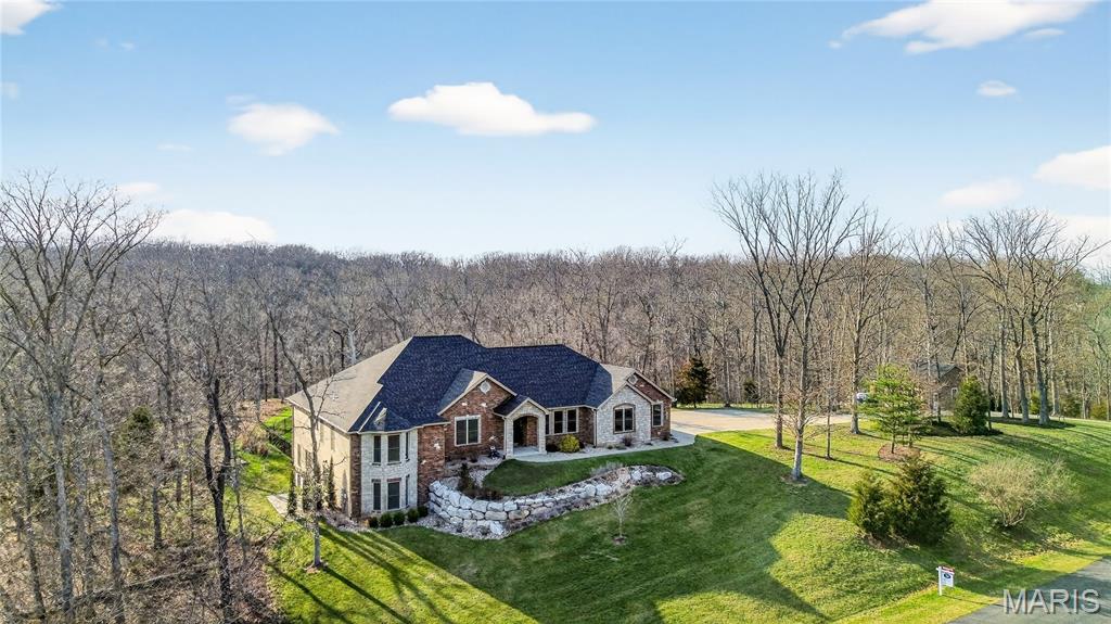 An impressive brick & stone elevation highlights the remarkable curb appeal of this spectacular great room ranch on wooded 3+ ac grounds. Impressive hardwood foyer leads to private study with French doors, elegant dining room framed by arched entryways & stunning great room with floor-to-ceiling stone fireplace flanked by built-in bookcases & expansive wall of windows. Designer kitchen with glazed white cabinetry, granite countertops, premium appliances & 8’ center island adjoins light-filled breakfast room. Spacious primary bedroom suite with tray ceiling, wide bay window & luxury bath with jetted tub offers an appealing retreat. 2 Additional bedrooms with Jack n’ Jill bath complete the main floor living quarters. Lower Level entertainment space includes recreation room, game room with wet bar, 4th & 5th bedrooms & full bath. Sliding glass doors open to screened porch, pool, hot tub & patio with firepit. In addition, property features an oversized 3-car garage & detached 3-car garage.