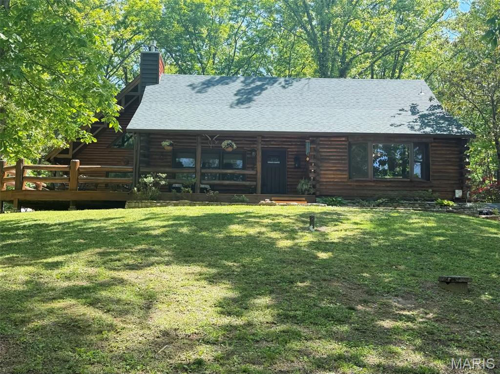 This HOME is it! Lake VIEWS on the largest 200 acre spring and creek fed lake in Jefferson County! Live in your vacation dream home year round with all the amenities Lake Tishomingo has to offer.  Scenic picnic areas with tables and grills for outdoor dining. Swimming beach for sunbathing and water activities. Hiking trails offering beautiful views and nature exploration. Fishing spots with opportunities for catching various species.  It's a Fisherman's delight -this lake is stocked with bass, crappie, blue gill, channel cat, and perch. Boat ramps for easy access to watercraft and recreational boating.  Volleyball, basketball, playground, picnic and beach area.  This meticulously maintained home is one of a kind, admired, filled with character, love and features that you can't find in most homes.  Your own personal lake life retreat! This custom log cabin with tongue and grove wood walls is in the perfect setting situated on 2+ acres - 9 connecting lots and 1 lake front lot directly across the road for easy access to lake, with a shed to store your fishing gear. It's ready for you to design and install your own boat dock.  Let's talk about the multi-use outdoor living space.  Do you like to entertain? There are plenty of places to gather here-take your pick-you have a 22x16 covered front porch, connecting to the 32x17 side deck with massive log rails. If that doesn't give you enough room then you can utilize the concrete wrap around patio that leads to the back of the house that enters into another extra large secluded patio that would be great for grilling, cookouts or a firepit seating area for all your guests to hangout.  This outdoor space has been well thought out and planned for even someone who needs wheel chair accessibility. The back patio area makes it easy to pull right up to it and unload groceries. What is unique about the lot is you have your own private gravel road entrance on the back side which provides lots of parking for all those guests or drive around the bend to the front and use the long concrete driveway up to the house which provides ample parking including a garage and portico to park under.  The outdoor enthusiast can enjoy bountiful nature bird watching and all the wildlife around you. Children and pets won't run out of space in this yard...plenty of space for them to play.  LET'S STEP INSIDE NOW-the original cabin greets you with a soaring vaulted ceiling in the Great Room and tongue and grove through out the rest of the house with a stone masonry wood burning fireplace and massive log mantle, custom built in bookcase, open staircases going up to your own private bedroom retreat with ensuite bathroom or head down to the finished walk out lower level that makes a great game room or home office.  The tuck under garage has a new epoxy floor and has ample storage and closets to keep everything organized.  Enjoy your large eat in kitchen with thick wood ceiling beams, custom chandelier and plenty of natural light with the big picture window to gaze out at the lake while sipping your morning coffee. The newest addition with 1000 sq ft has it's own private entrance but also connects to the other side with a large foyer.  Use it as the your Primary bedroom or in-law quarters with private ensuite, kitchenette, living room, dining and a gracious loft for additional sleeping for guests that the current homeowners call the Tree House due to the custom staircase that was designed and installed by a local artist. New roof 2025, gutters & leaf guards, deck stained 2025, entire home stained/sealed in 2024 and new entry door.  Exterior Features: Stone retaining walls, flower beds, flagstone sidewalk, landscape garden, custom mailbox, wrap around deck and sidewalk, firewood rick. Interior Features: durable flooring wood and ceramic throughout, 3 Stone fireplaces-Wood burning in Great room and 2 gas log fireplaces in the Living room and lower level for those chilly nights to snuggle up on the couch