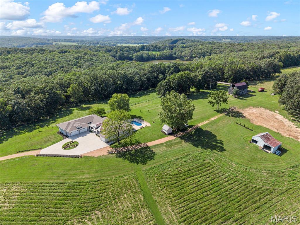 43± ACRE FARM • PASTURE • WOODS • STOCKED POND • BARNS • HUNTING & RECREATION
Bring the horses, livestock, ATVs and hunting gear! 8120 Angell Road offers 43± acres of beautiful Missouri countryside with the land, infrastructure and versatility to create the rural lifestyle you've been looking for. Whether your dream is a working or hobby farm, homestead, hunting property, equestrian setup or private recreational retreat, this property delivers.
The acreage offers an ideal combination of open pasture, fenced grazing areas, gently rolling ground and wooded acreage, providing plenty of room for horses, cattle, goats and other animals while also creating private hunting and recreational ground right outside your back door. Explore the woods, establish hunting areas, ride ATVs or horses, hike your own property, or spend the afternoon fishing the stocked pond.
The farm infrastructure is already here with a barn, pole barn, multiple sheds, workshop space and water available at the barn and tool shed. An incredible 6-car garage setup, including a temperature-controlled detached garage/workshop with half bath, provides exceptional space for tractors, UTVs, trailers, farm equipment, tools, projects and recreational toys.
At the heart of the property sits a beautifully renovated 4-bedroom, 2.5-bath farmhouse with approximately 2,753 sq. ft. Inside you'll find hardwood floors, a masonry wood-burning fireplace, spacious living areas and an updated kitchen featuring an oversized center island, abundant cabinetry, solid-surface countertops and stainless appliances. The main-level primary suite offers a peaceful retreat with access to the covered outdoor space.
When the work is done, enjoy the private pool, stocked pond, sweeping country views and 43± acres of your own Missouri ground.
Farm it. Hunt it. Fish it. Ride it. Raise animals. Create your homestead or recreational getaway. With pasture, woods, water, fencing and substantial outbuildings already in place, 8120 Angell Road is more than a home on acreage—it's an opportunity to build the country lifestyle you've been dreaming about.