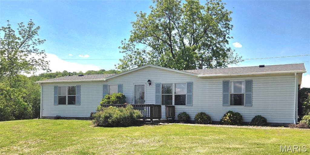 Looking for quiet, rural living?  Come see this spacious updated manufactured home sitting on 4 acres.  Step inside to an open-concept floor plan with vaulted ceilings and abundant natural light.  Outside you'll enjoy the open covered back porch overlooking mature trees and open land ideal for gardening or building a workshop.  Enjoy the shared lake as a perk of being a part of the Sugar Hill Subdivision!   Upgrades include a new roof and waterproof, scratch proof, laminate flooring.  Outbuildings include a shed primarily used as a garden shed while a portion is sectioned off as it once was used as a chicken coop.  This is the perfect opportunity to create your private oasis-start your hobby farm, build a massive shop, or simply enjoy the tranquility.  Schedule your showing today!