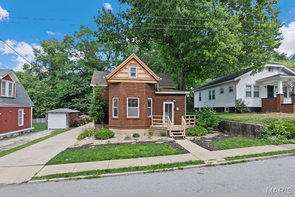 Wait until you see this one! This charming 4-bed, 2-bath cedar home is full of character, space, and beautiful updates in an unbeatable location. Step inside to a bright, open living room featuring gorgeous built-in bookcases and a cozy gas corner fireplace, creating the perfect gathering space. The updated eat-in kitchen is both stylish and functional with a large center island, an adorable pantry, and all kitchen appliances included. A versatile bonus room just off the kitchen provides the perfect space for a home office, mudroom, or family room. The convenient main-level primary suite offers privacy and flexibility, while three additional bedrooms and a full bath upstairs provide plenty of room for family, guests, or work-from-home needs. The large unfinished basement offers abundant storage space, laundry hookups, and endless possibilities for a workshop, hobby area, home gym, or future expansion. Step outside to enjoy the spacious deck overlooking a beautiful, private backyard, perfect for entertaining or relaxing. A long driveway leads to the detached 1-car garage with an attached carport, offering ample parking and additional storage. Conveniently located close to SIUE School of Dental Medicine and just minutes from shopping, dining, parks, and major highways, this move-in-ready home combines timeless charm, modern updates, and exceptional functionality. Don't miss your opportunity to make this one your own!