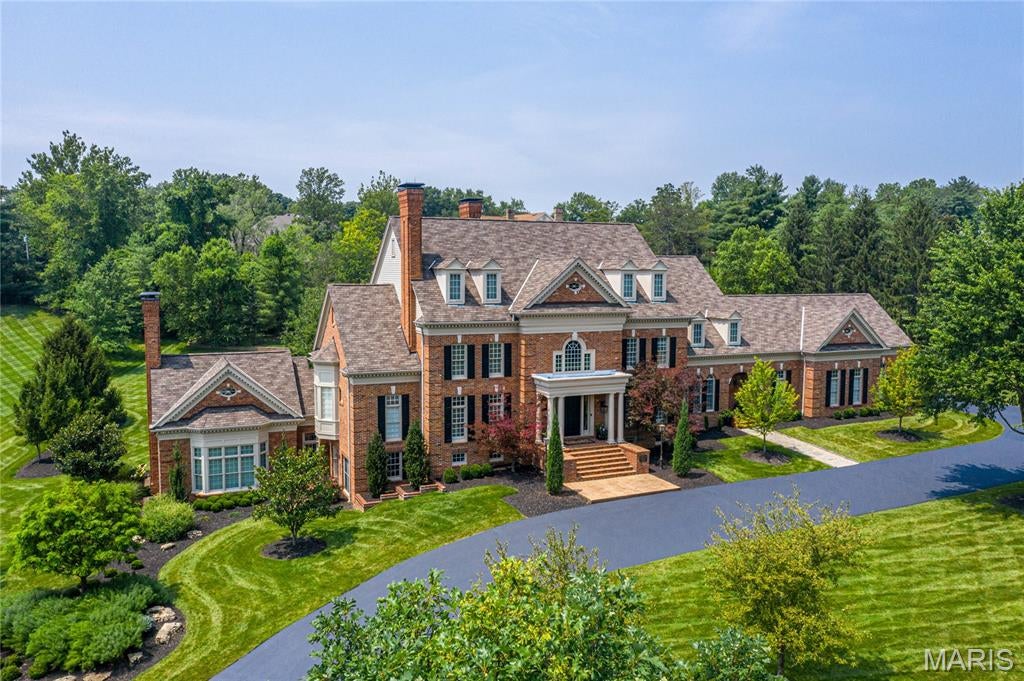Magnificent Grotpeter-crafted 1.5-story Georgian estate gracefully positioned on 1.8 park-like acres within the prestigious gated enclave of Buckland Hall. This extraordinary residence showcases timeless architecture, exceptional craftsmanship, and elegant living spaces designed for both grand entertaining and everyday comfort. A breathtaking two-story marble foyer welcomes you and opens to a distinguished private study featuring a marble fireplace and custom built-in bookcases, an elegant formal dining room, and an impressive great room highlighted by soaring ceilings, arched entryways, and a magnificent stone fireplace. The gourmet designer kitchen offers 60-inch white custom cabinetry, granite countertops, commercial-grade appliances, and adjoins a charming breakfast room with a groin-vault ceiling and serving bar. The adjoining vaulted hearth room features a dramatic floor-to-ceiling fireplace and French doors leading to a sun-filled four-season room overlooking the spectacular grounds. The luxurious main-level primary suite provides a private retreat with a spa-inspired marble bath, oversized shower, and refined finishes throughout. The upper level expands the home's exceptional accommodations with five additional bedrooms, a spacious bonus room with fireplace, and three full baths. Designed for entertaining, the finished lower level features a recreation room with the home's fifth fireplace, a family room, gathering bar, climatized wine cellar, second full kitchen, sleeping area, private office, fitness studio, cathedral vaulted billiard room, one full bath and two half baths. French atrium doors lead to an extraordinary outdoor oasis complete with a resort-style swimming pool, pool house, beautifully landscaped gardens, and an expansive patio with fire pit, creating an exceptional setting for relaxing or entertaining. This remarkable Buckland Hall estate represents luxury living at its finest, combining timeless Georgian elegance with outstanding amenities in one of the area's most sought-after gated communities.