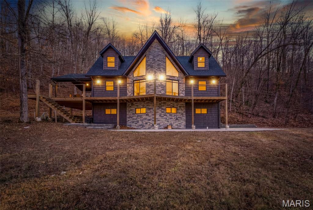 Gorgeous custom home in private/gated community with 13+/- acres - this one is a show stopper! This story and a half custom home sits next to the creek and just minutes from the community common ground access and frontage to the crystal clear, spring fed Black River. The main floor features a 2 story custom stone fireplace, marble hearth, custom mantle and hardwood flooring with floor to ceiling windows for those gorgeous views. Open concept is perfect for entertaining especially in this large kitchen with full length breakfast bar featuring leathered marble counter tops, custom cabinetry with soft close doors and several custom drawers and cabinet pull outs-Half bath right off the kitchen has laundry hook up too. Primary suite on the main floor features hardwood flooring, large walk-in closet and a stunning ensuite with double vanity, tiled flooring and a huge walk in, tiled shower with rain shower and handheld shower heads. Upstairs has 2 very nice sized bedrooms and a full bathroom with tub/shower combo. Sit out on the deck under the stars and listen to the creek on the edge of the property. This home is ready with all furnishings for your primary residence or your getaway home on your own slice of heaven. Come on out and see why you too should be a part of this community where everyone becomes like family! Must have agent appointment please do not enter gates without your agent. Home is offered as is with all furniture to remain.