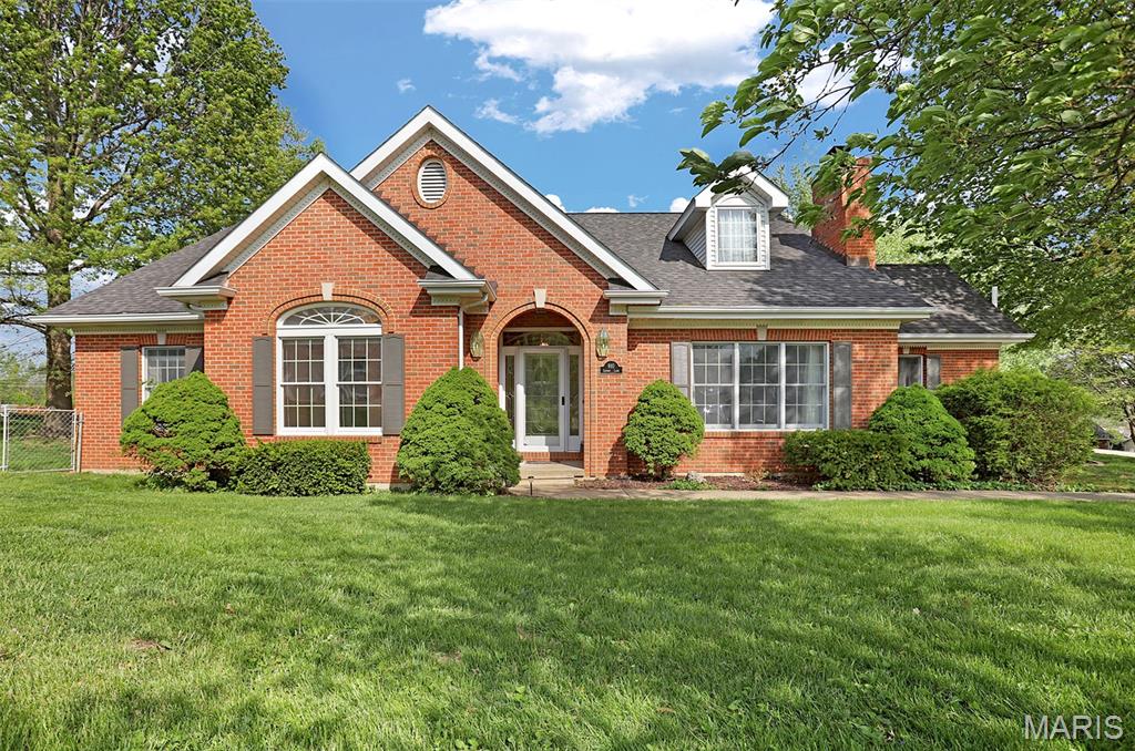 Beautiful, brick-front home on right under 3/4 of an acre with a 4-season room overlooking the beautiful backyard with mature trees. This attractive property is in great condition, originally constructed in 1991. It offers a lead glass front door, hardwood flooring and custom millwork. An open floor plan interior fosters an expansive and inviting environment throughout. The kitchen, a central element of the interior, offers an eat-in breakfast area and features stylish stone backsplash and updated appliances, complemented by a practical kitchen peninsula. Within the living room, a welcoming fireplace creates an inviting atmosphere. Beyond is the formal dining room. The primary bathroom offers the convenience and ease of a walk-in shower. Outside, residents can enjoy a quiet patio, an invigorating hot tub, and an outdoor dining area, all within fencing for privacy, creating a perfect setting for outdoor enjoyment. This property provides four bedrooms and 4.5 bathrooms, accommodating various familial needs. Downstairs is finished with an additional kitchen, family room, sleeping/office area and bath. This home has a 3-car garage with extra space for all your toys. Have all the convivences of in town living with privacy on a quiet street. This residence offers a distinguished living experience, thoughtfully designed for comfort and enjoyment.